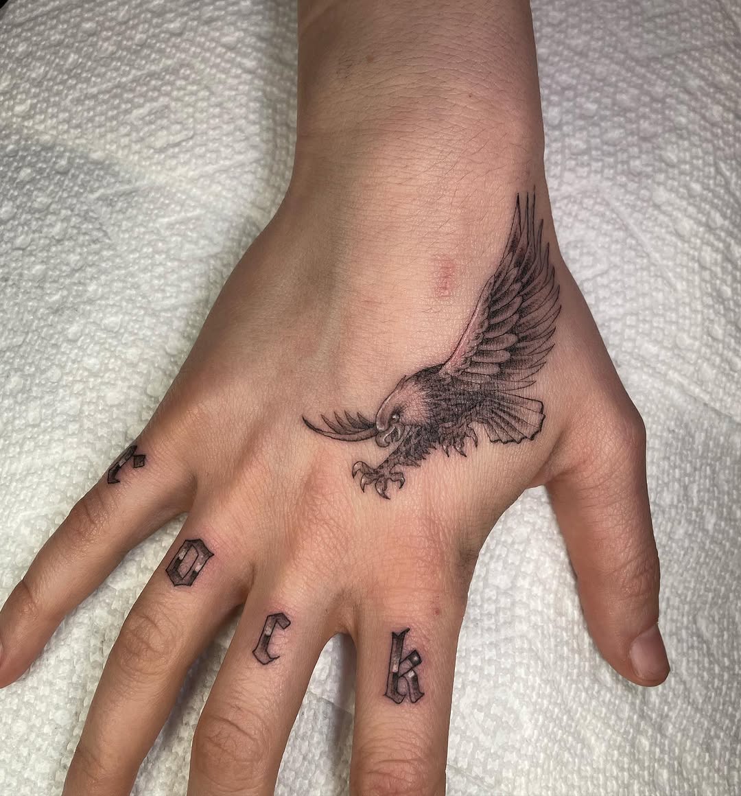 Eagle and lettering fine line tattoo on the hand by Jesus A.