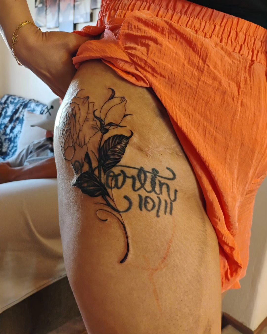 Flower and cursive text black and grey tattoo on the thigh by Alfredo Sosa