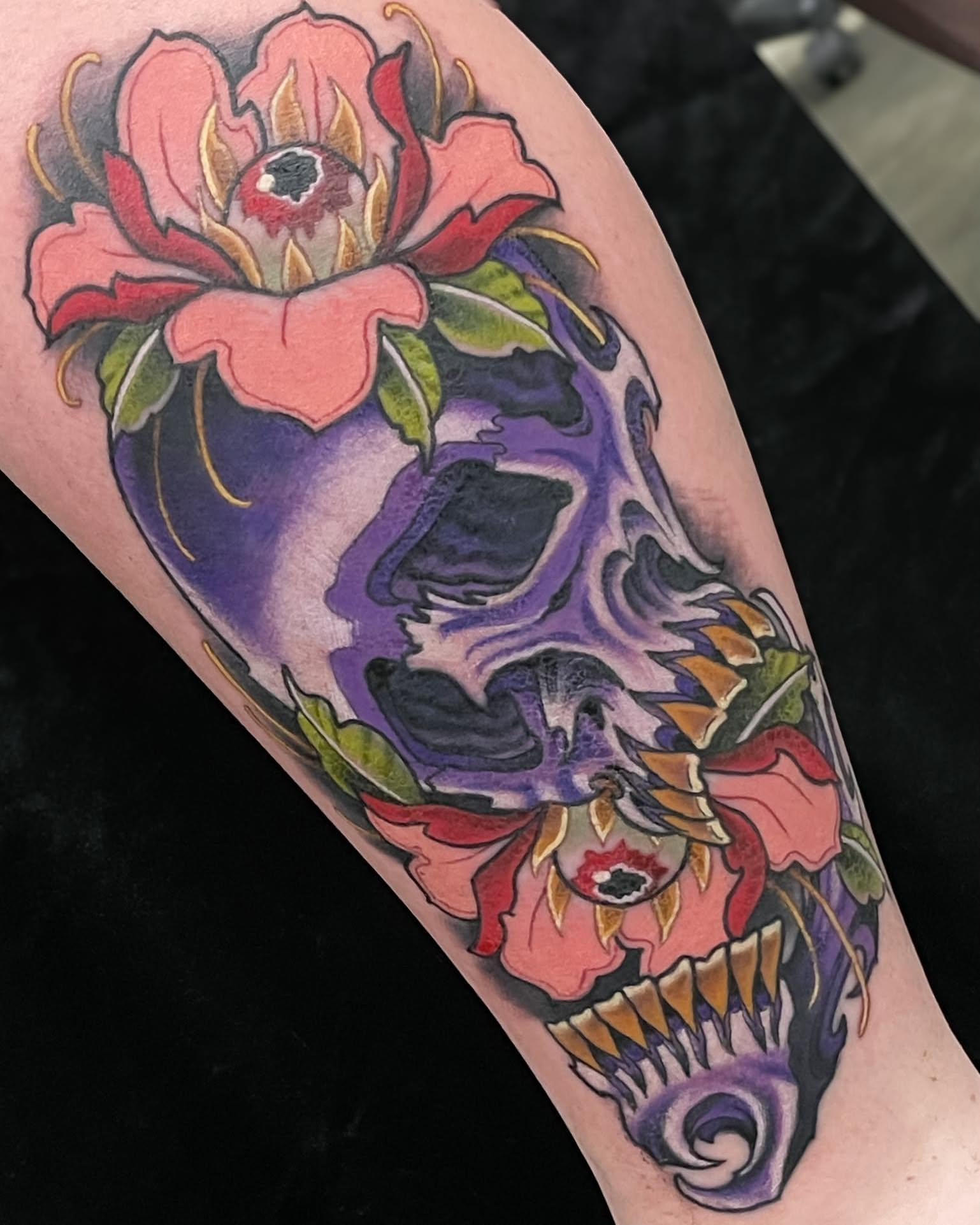 Skull and flowers American traditional tattoo on the forearm by Corra Carmine