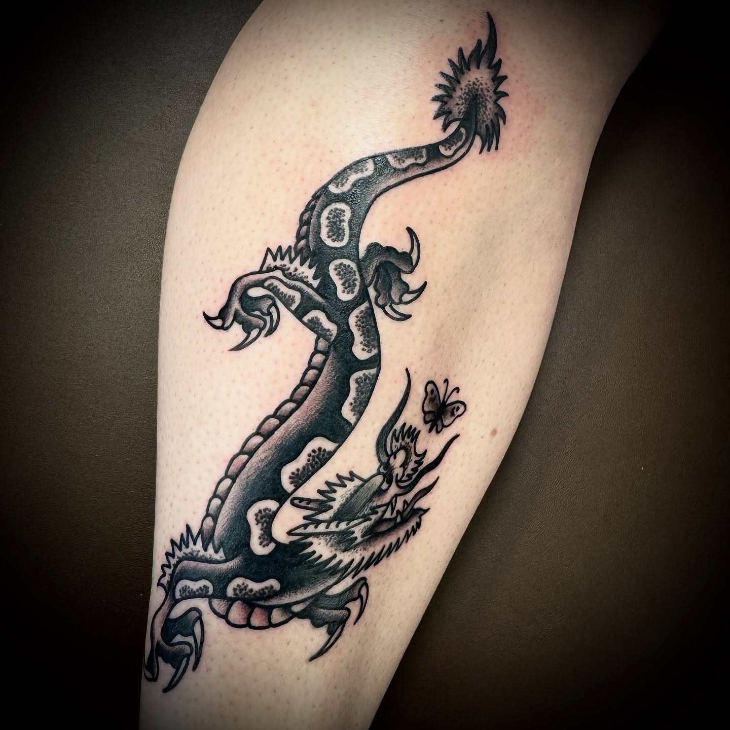 Dragon black and grey tattoo on the forearm by Kristen