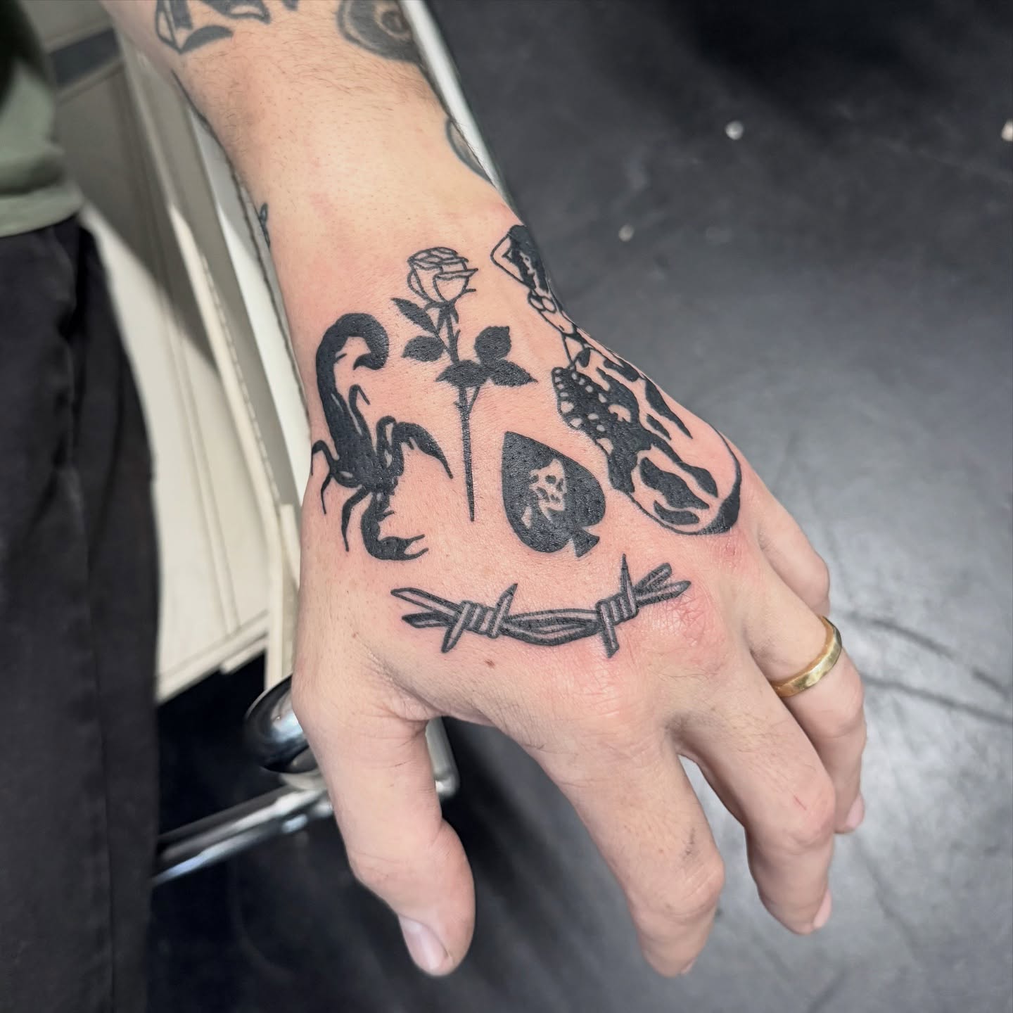 Scorpion, rose, skull, barbed wire black and grey tattoo on the hand by Han shinko, Portland, Oregon