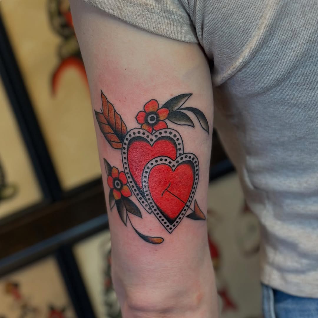 Two hearts with flowers American traditional tattoo on the forearm by @ryleecoyote, New York, New York