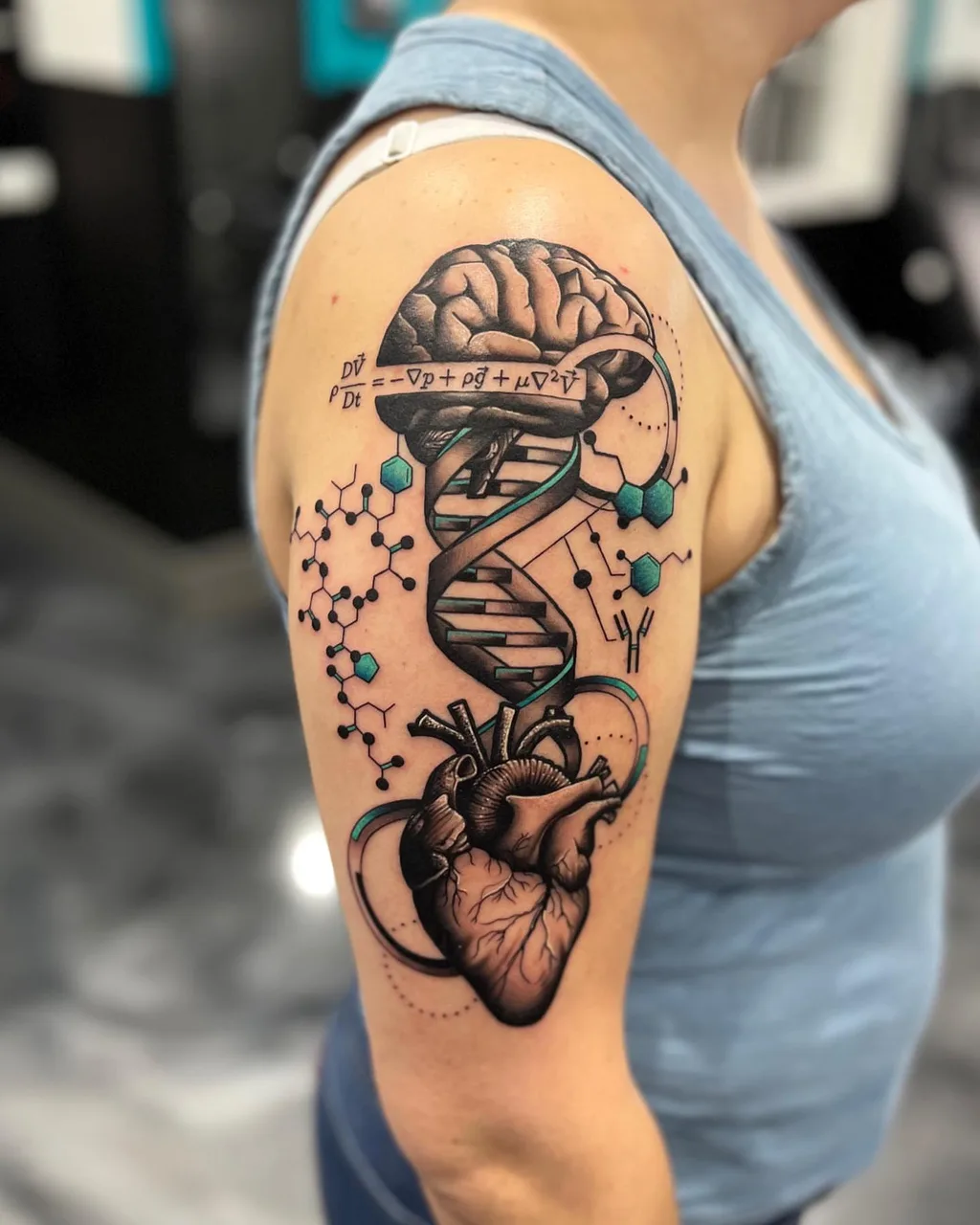 Brain, DNA, heart, molecular structures geometric tattoo on the shoulder by Adam Silfies