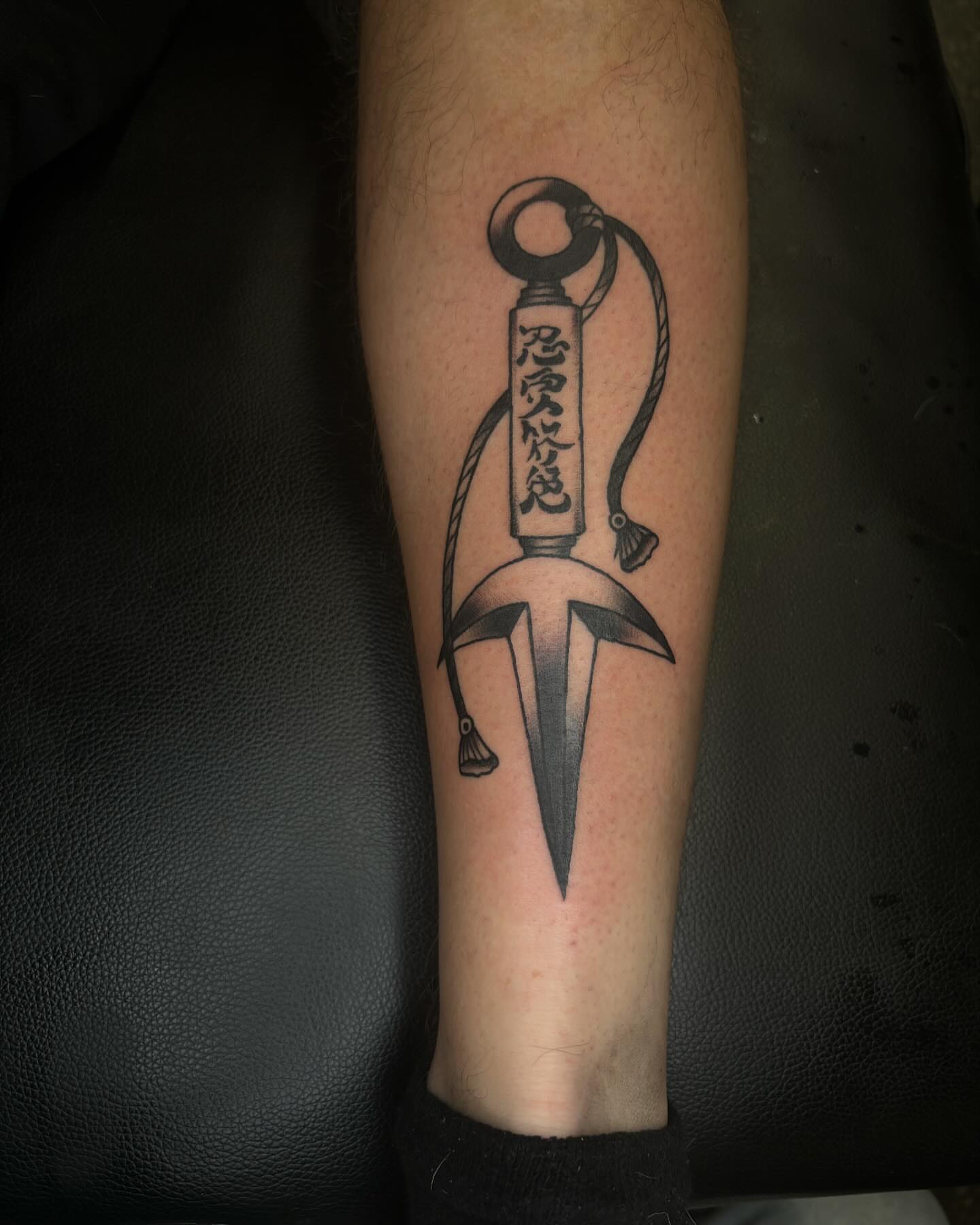Dagger with rope black and grey tattoo on the forearm by Brett Ferguson