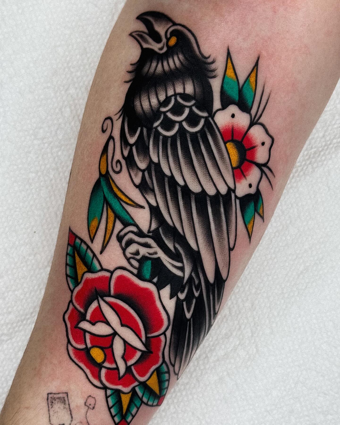 Crow and flowers American traditional tattoo on the forearm by Samuel Dickey