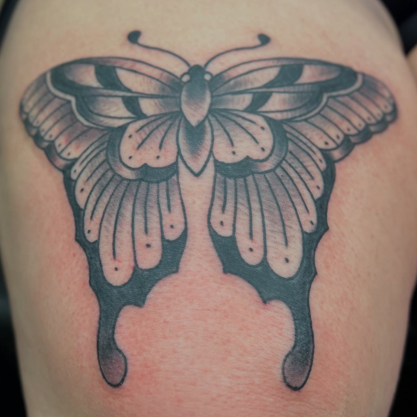 Butterfly black and grey tattoo on the thigh by Alex Fannin