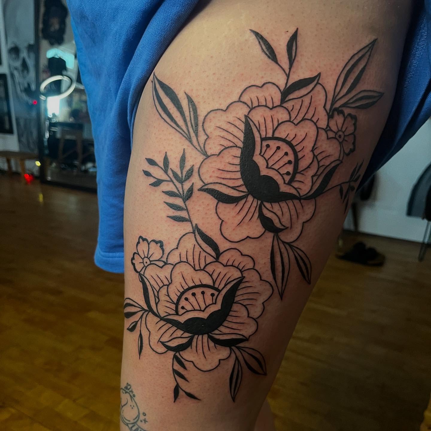 Floral bouquet black and grey tattoo on the thigh by Mariah Nguyen