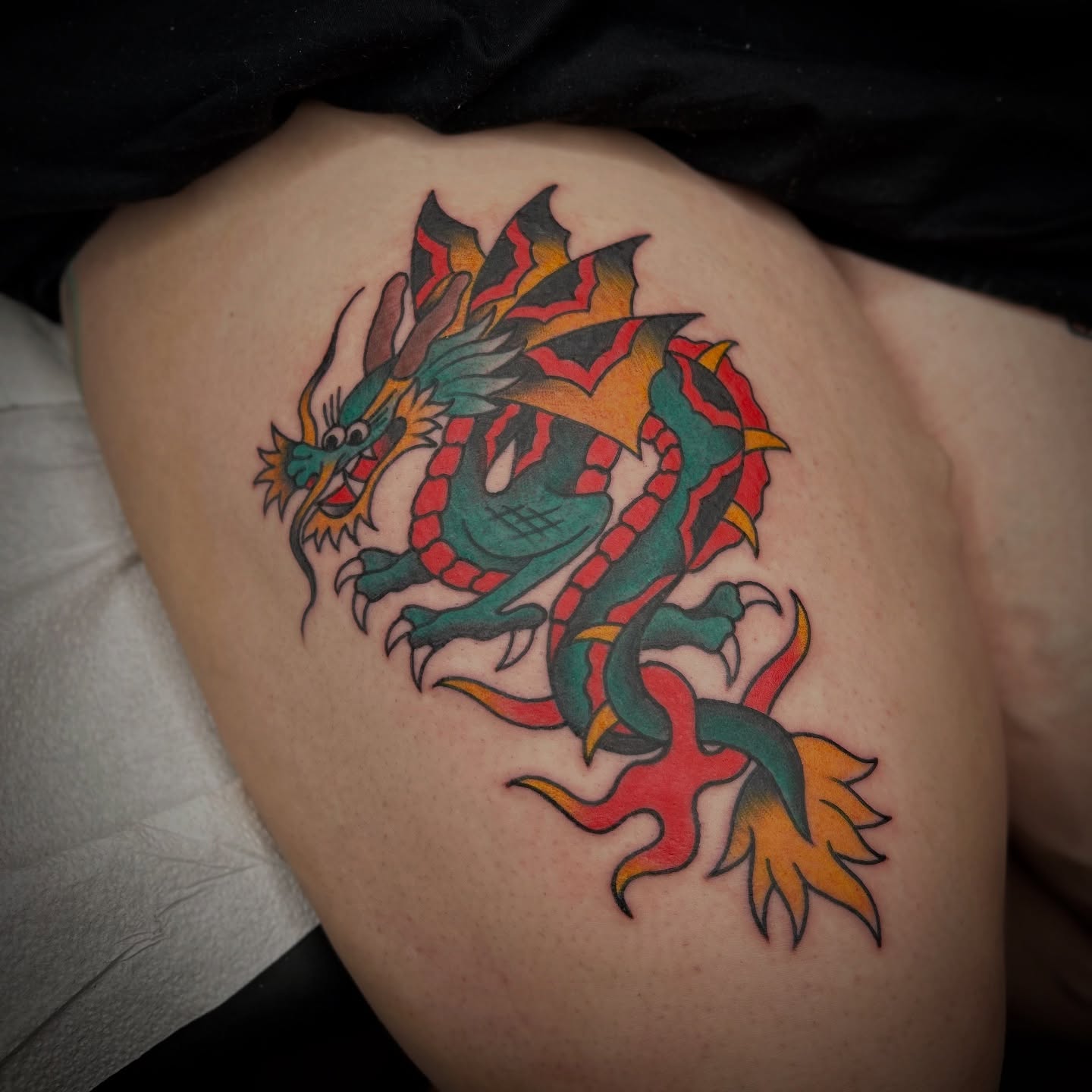 Dragon American traditional tattoo on the thigh by Bright-bold-classic Tattoos, North Hills