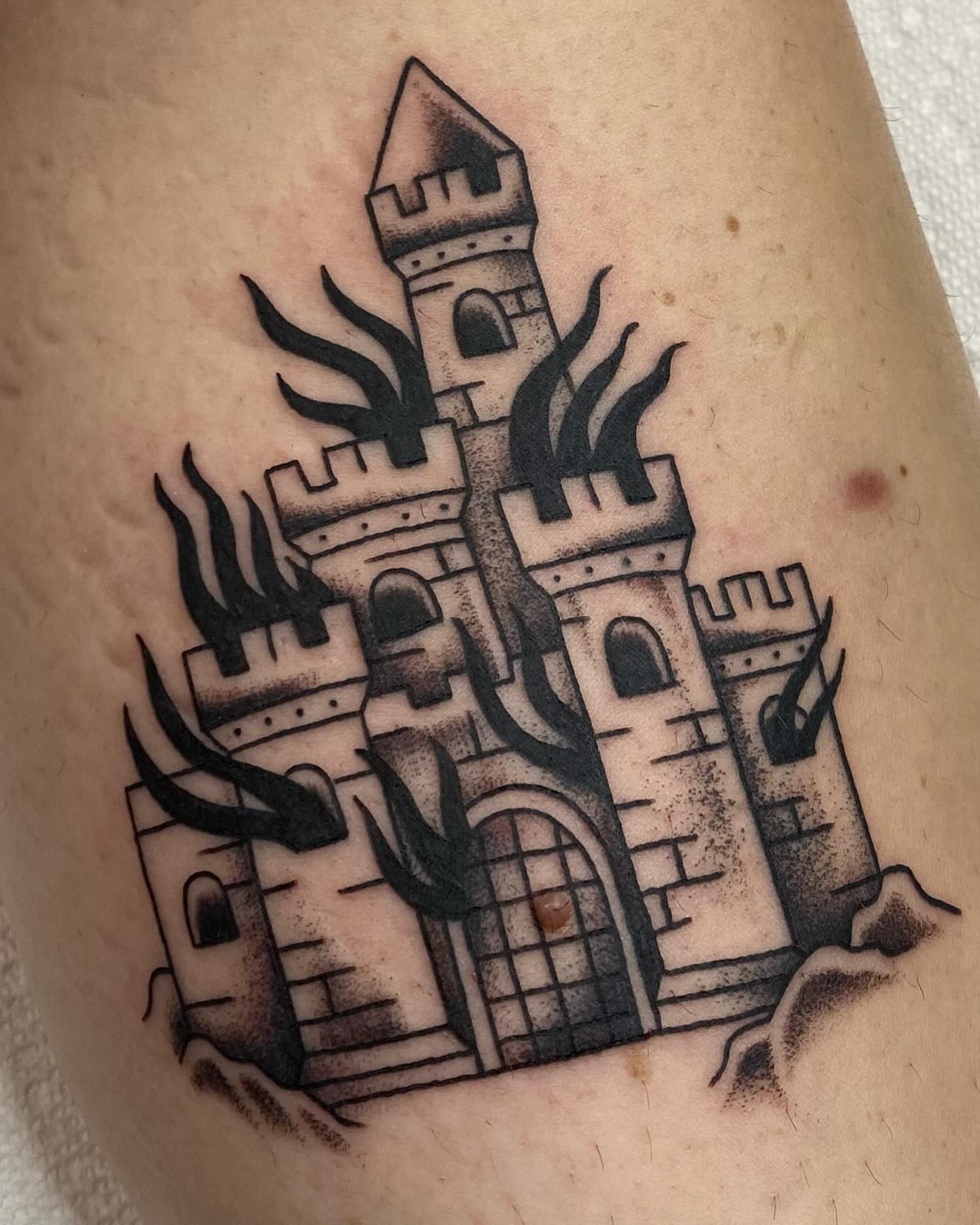 Castle with flames black and grey tattoo on the forearm by Kiera ❤️‍🔥