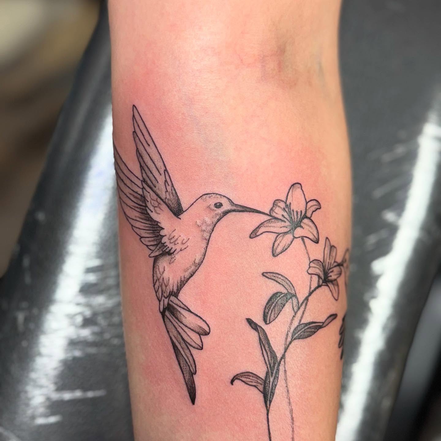 Hummingbird and lilies realism tattoo on the forearm by Mickey