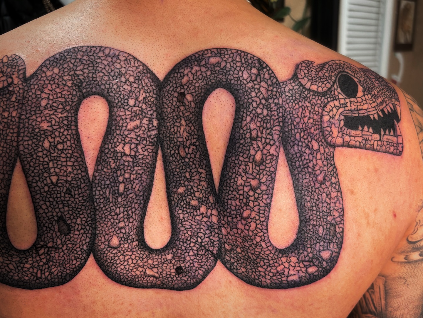 Snake dotwork tattoo on the back by Alexandria Gudiel