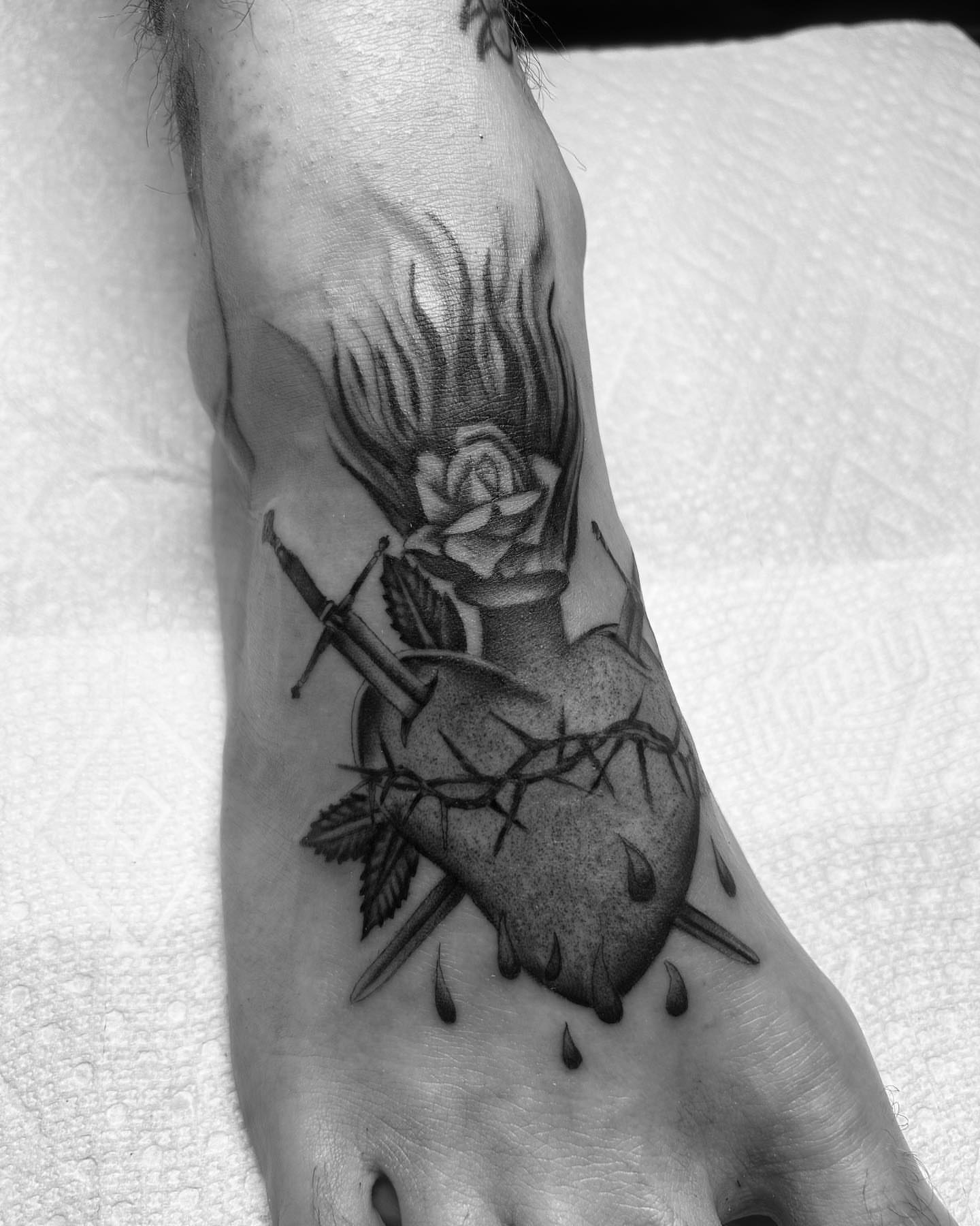 Heart with rose and nails American traditional tattoo on the foot by Alex Lang