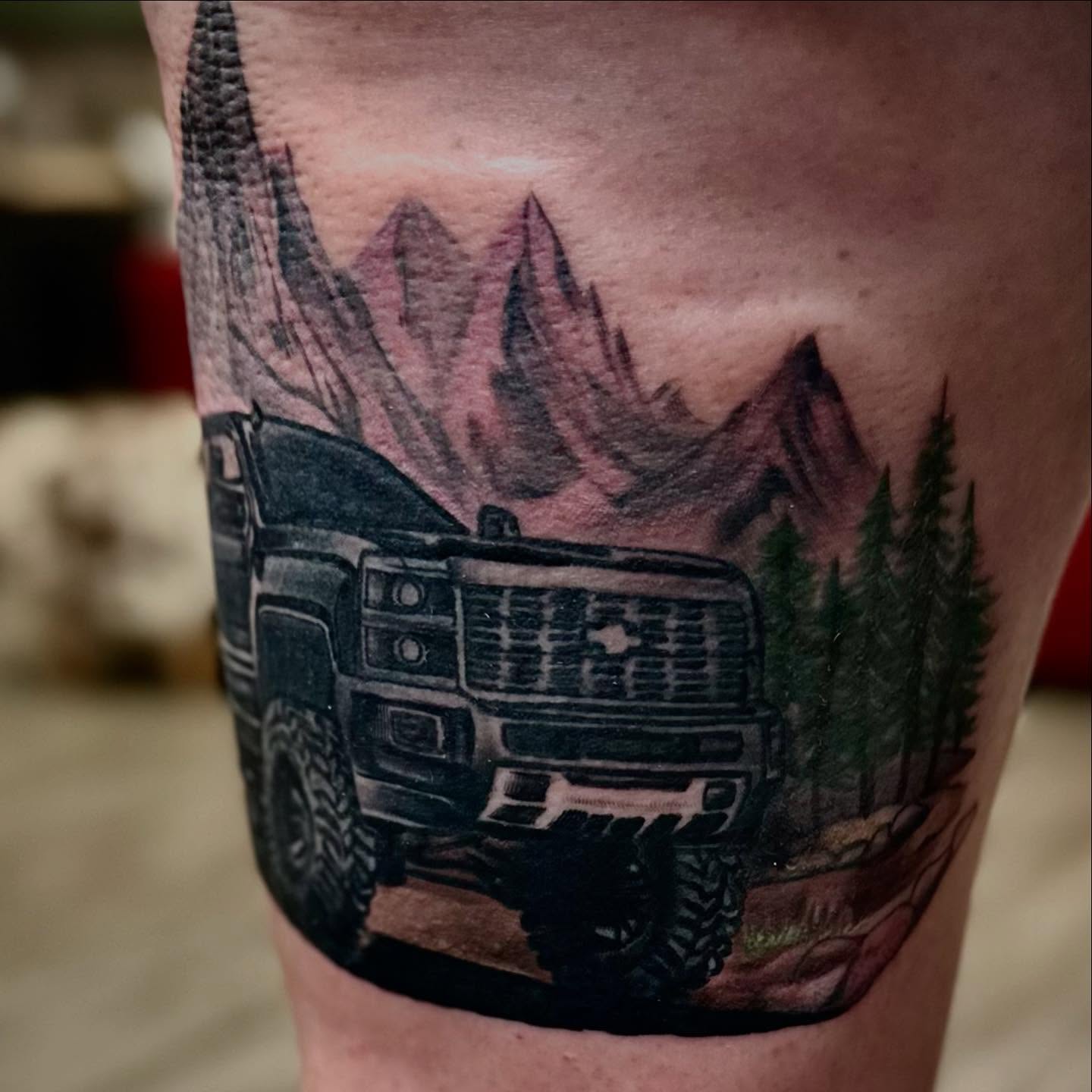 Off-road vehicle in mountain landscape realism tattoo on the thigh by Tattoo Artist Ian Day (Everlasting_Art_Ink)