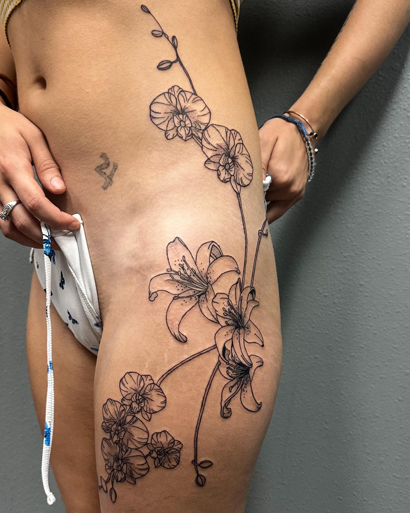 Lilies and orchids dotwork tattoo on the thigh by Portland Tattoo Artist