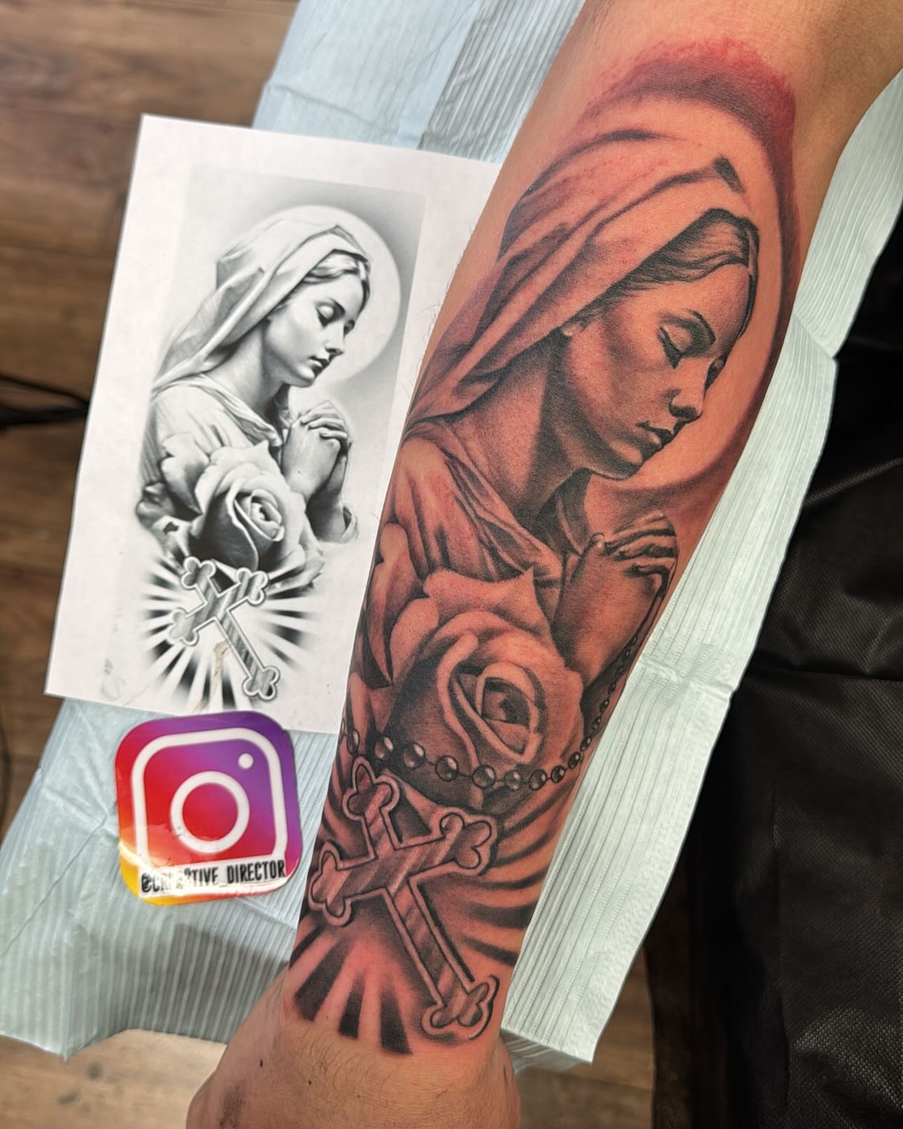 Religious figure with roses realism tattoo on the forearm by Cedric Fleming