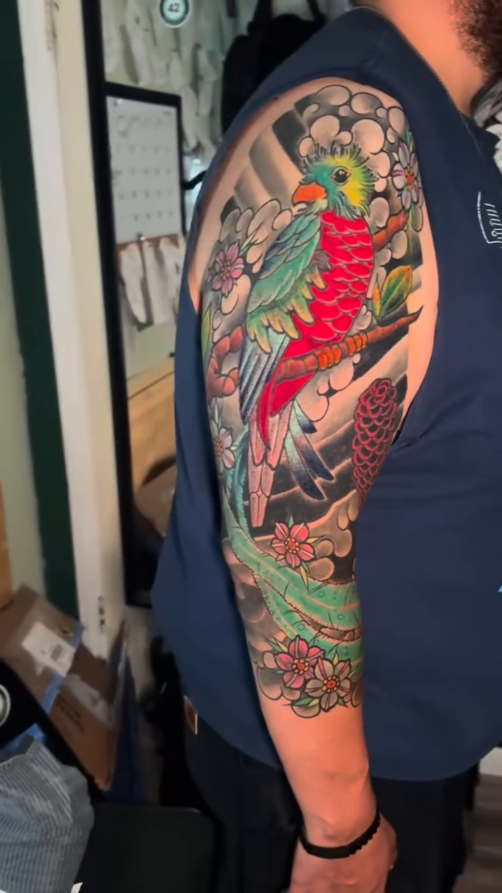 Parrot and flowers sleeve watercolor tattoo on the upper arm by Dustin Schild, Memphis, Tennessee