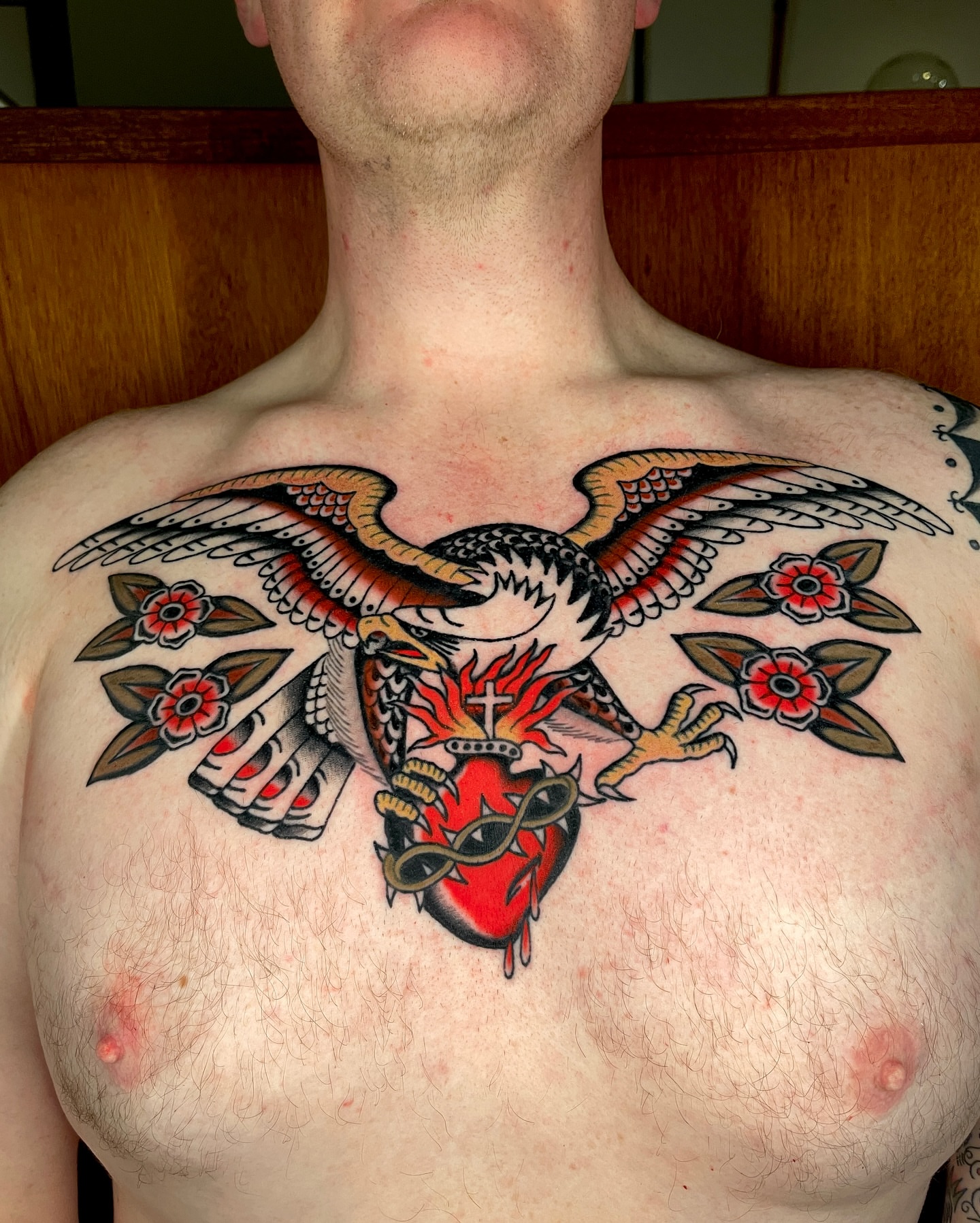 Heart with wings American traditional tattoo on the chest by Chase Tucker