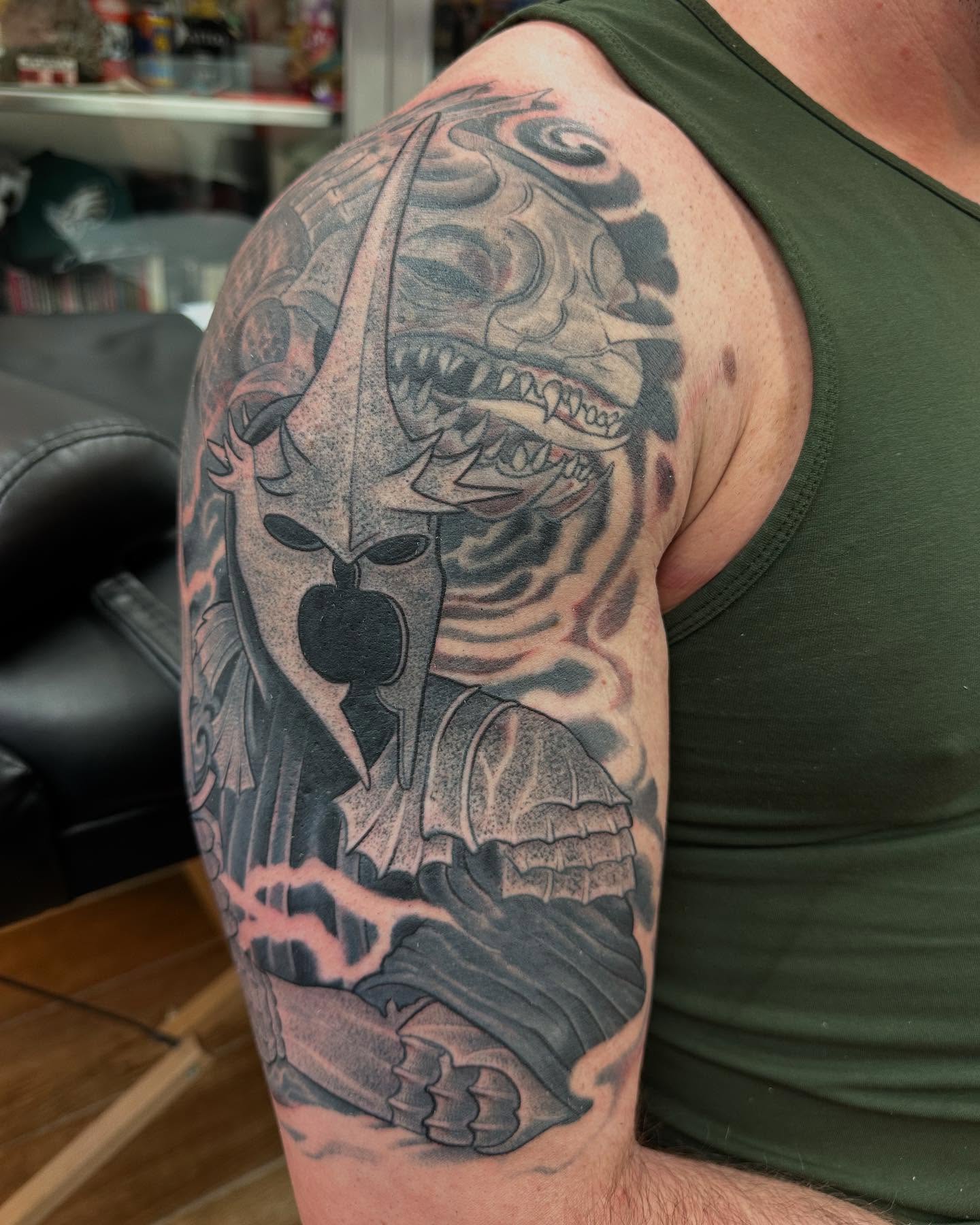 Mask with sword black and grey tattoo on the upper arm by Hori Bensei, Charlottesville, Virginia