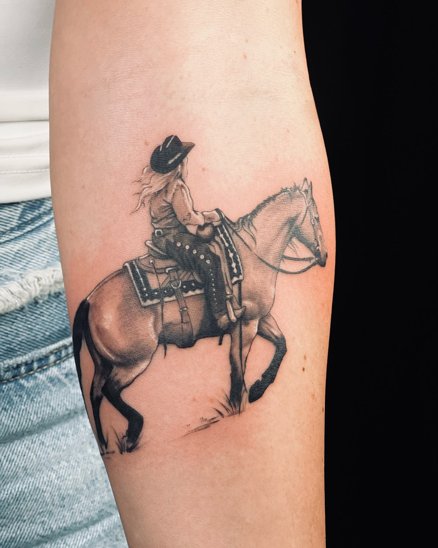 Cowgirl riding horse realism tattoo on the forearm by Apologies tattoo studios.