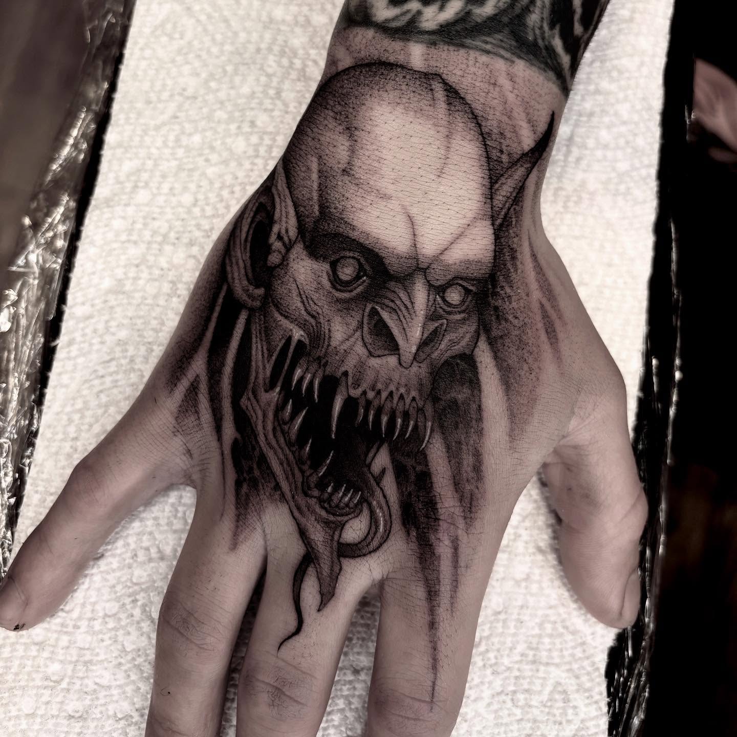 Demon face dark realism tattoo on the hand by Jens