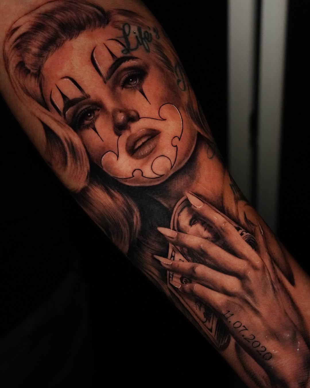 Woman with clown makeup Chicano tattoo on the forearm by Jennifer Garcia