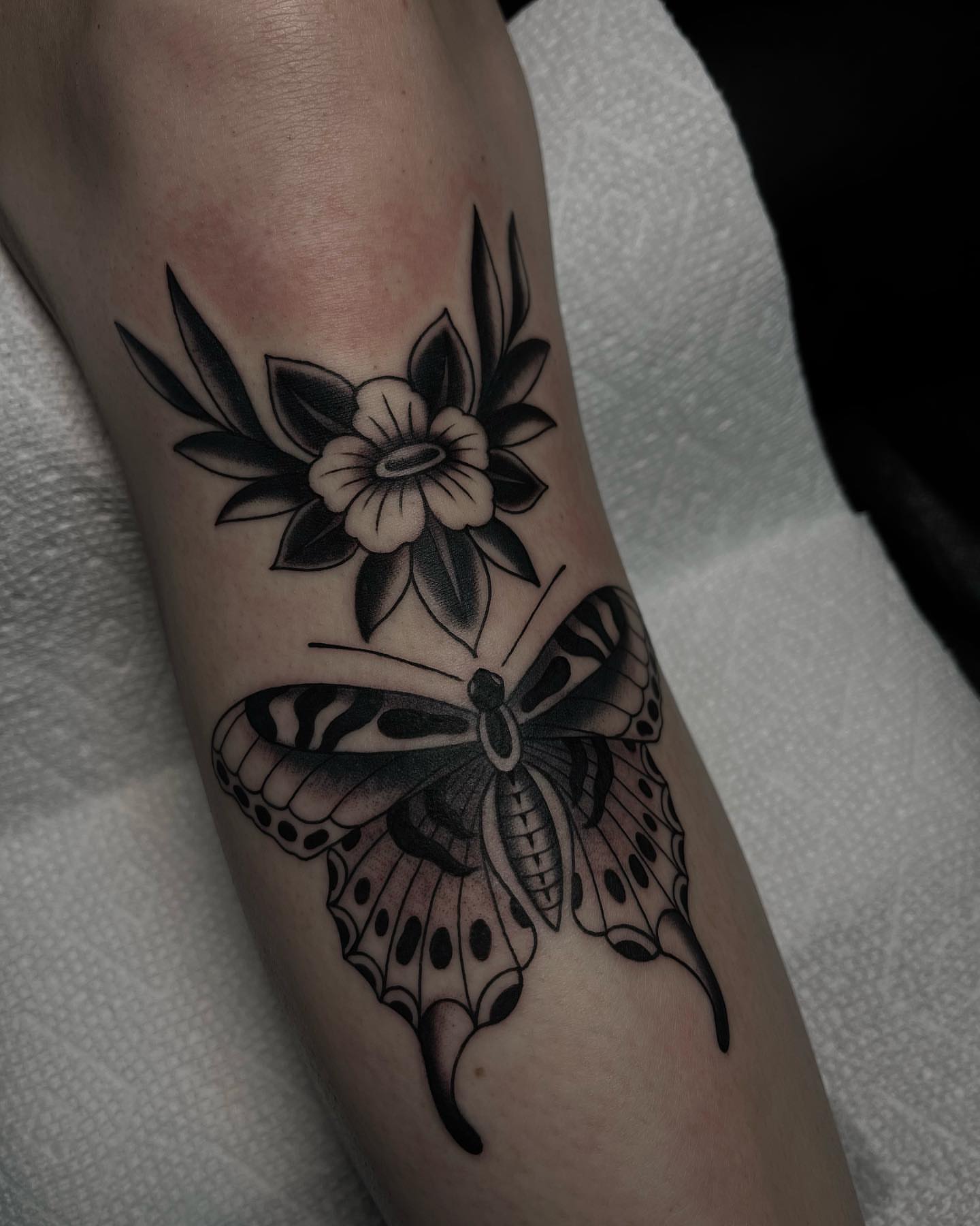 Butterfly and flower black and grey tattoo on the forearm by Kayla Faircloth, Charlotte, North Carolina