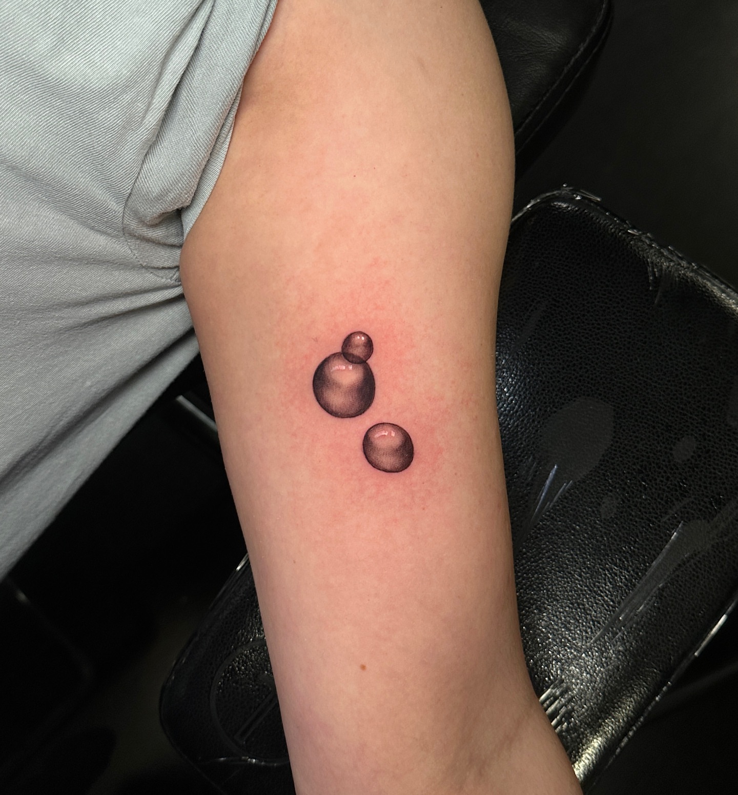 Three droplets dotwork tattoo on the forearm by Madeleine Fleming