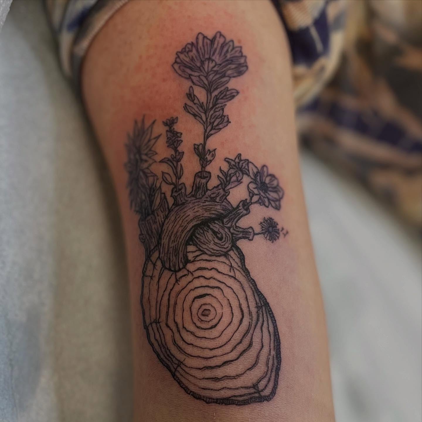 Heart and flowers realism tattoo on the forearm by Thea Curlee