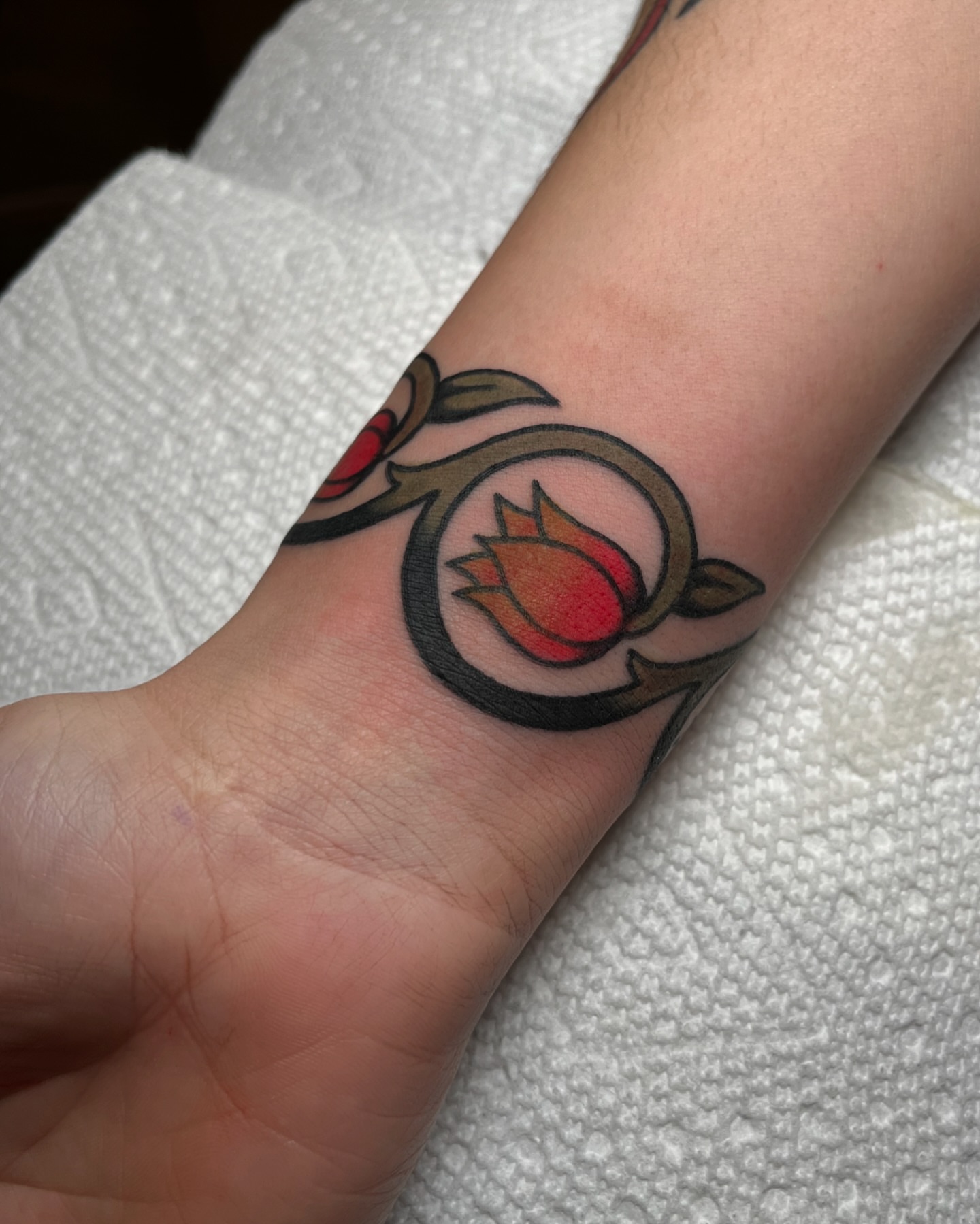 Flame and leaf neo-traditional tattoo on the forearm by kate