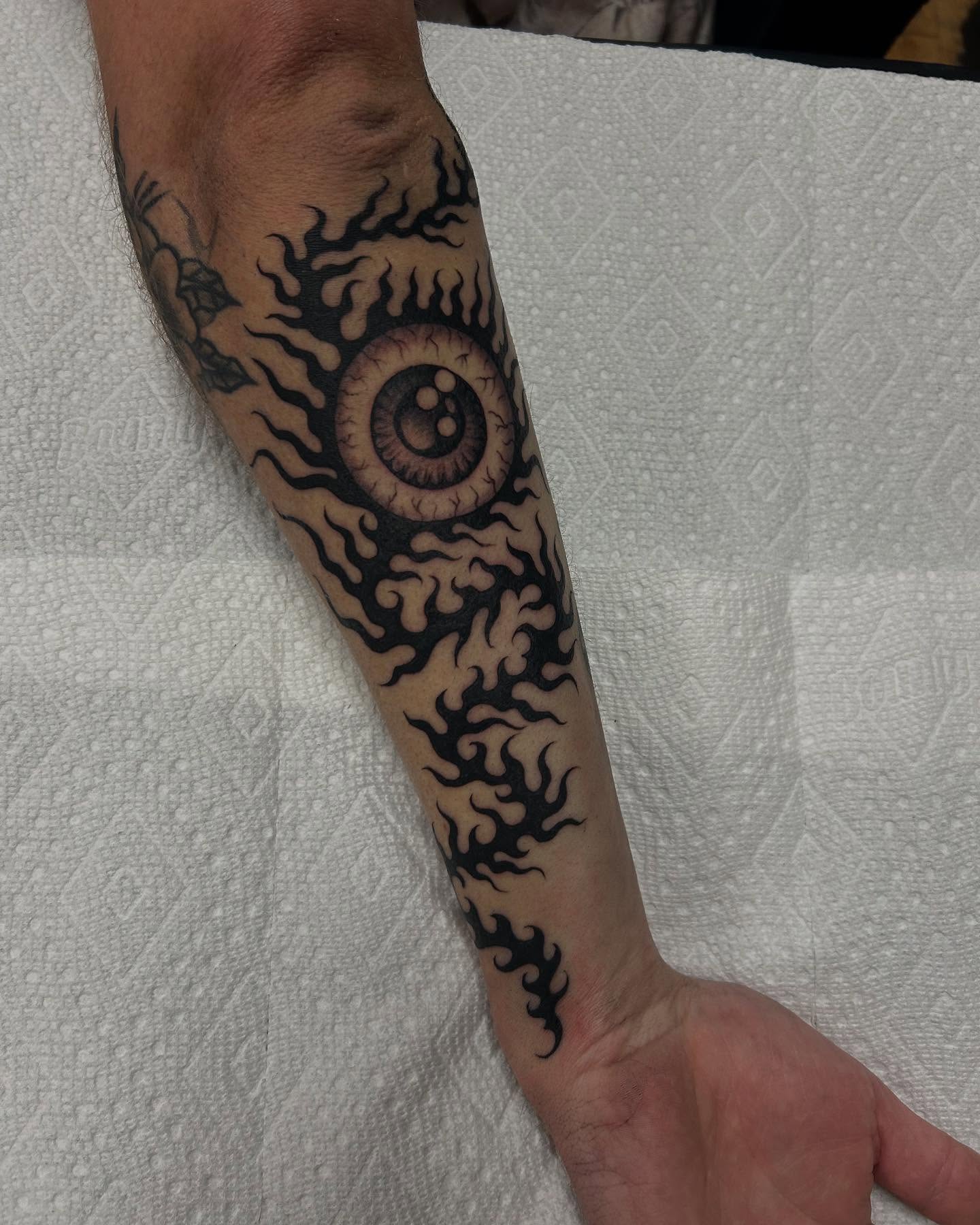 Eye with flames tribal tattoo on the forearm by Sam Perry, Denver, Colorado