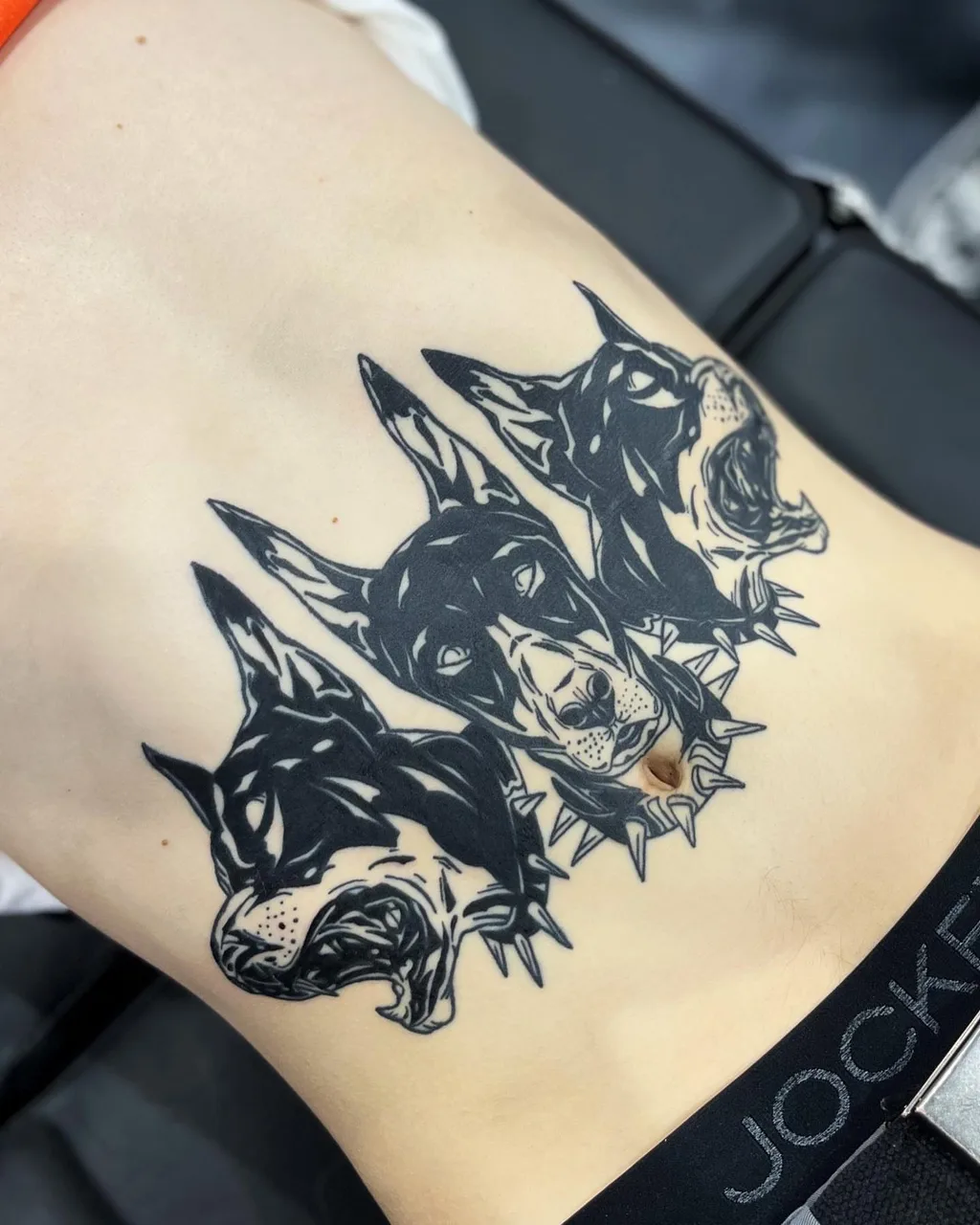 Dogs black and grey tattoo on the thigh by Adam Silfies