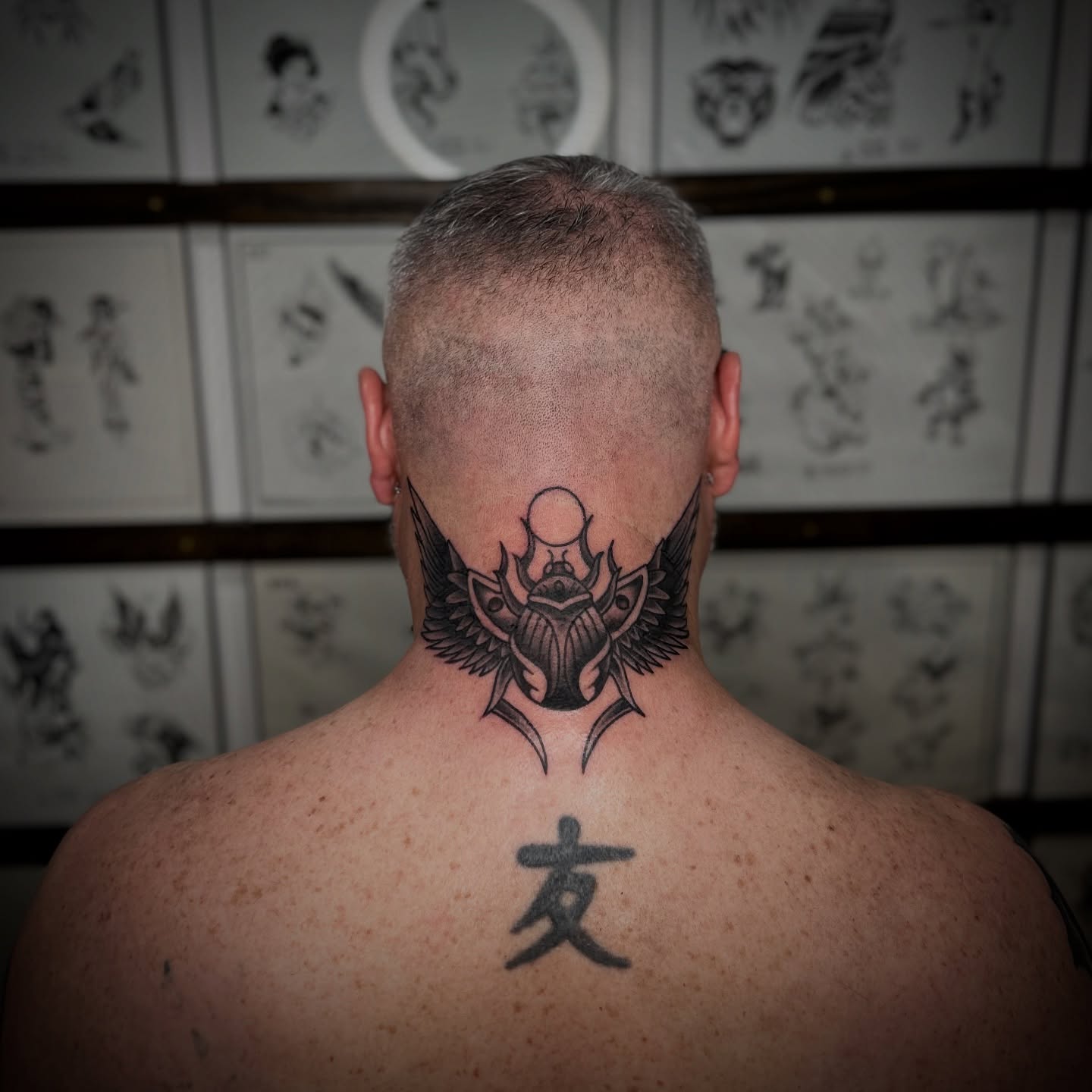 Scarab beetle black and grey tattoo on the neck by Bright-bold-classic Tattoos, North Hills