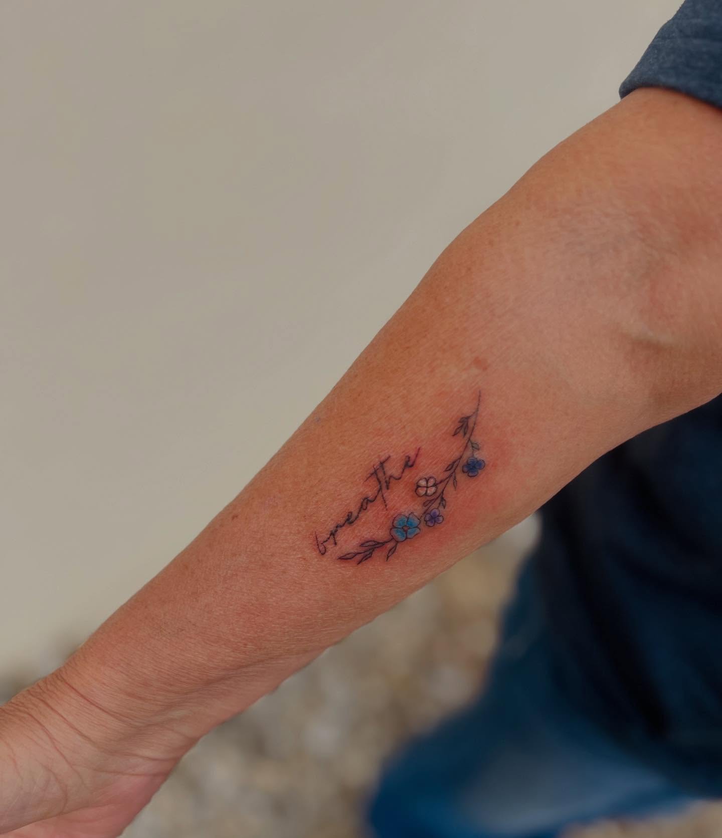 Breathe fine line tattoo on the forearm by Kylee Snow