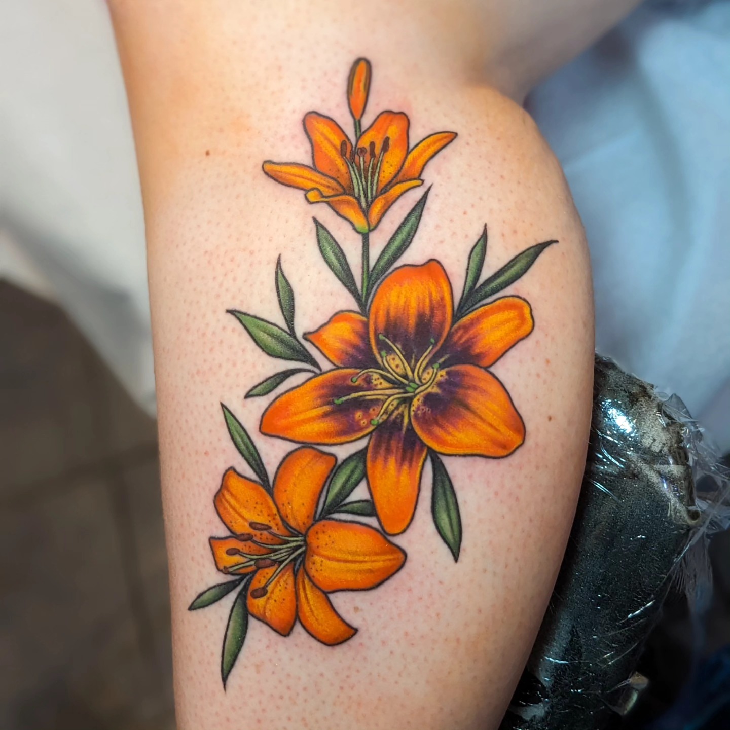 Orange lilies realism tattoo on the forearm by Matt Simmonds