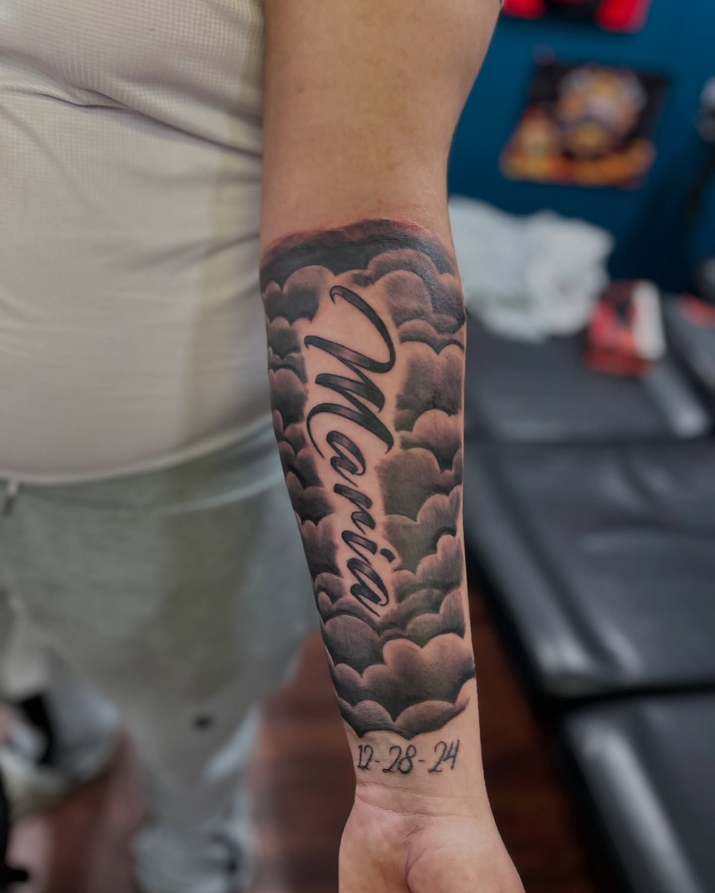 Clouds and name black and grey tattoo on the forearm by ๐AK