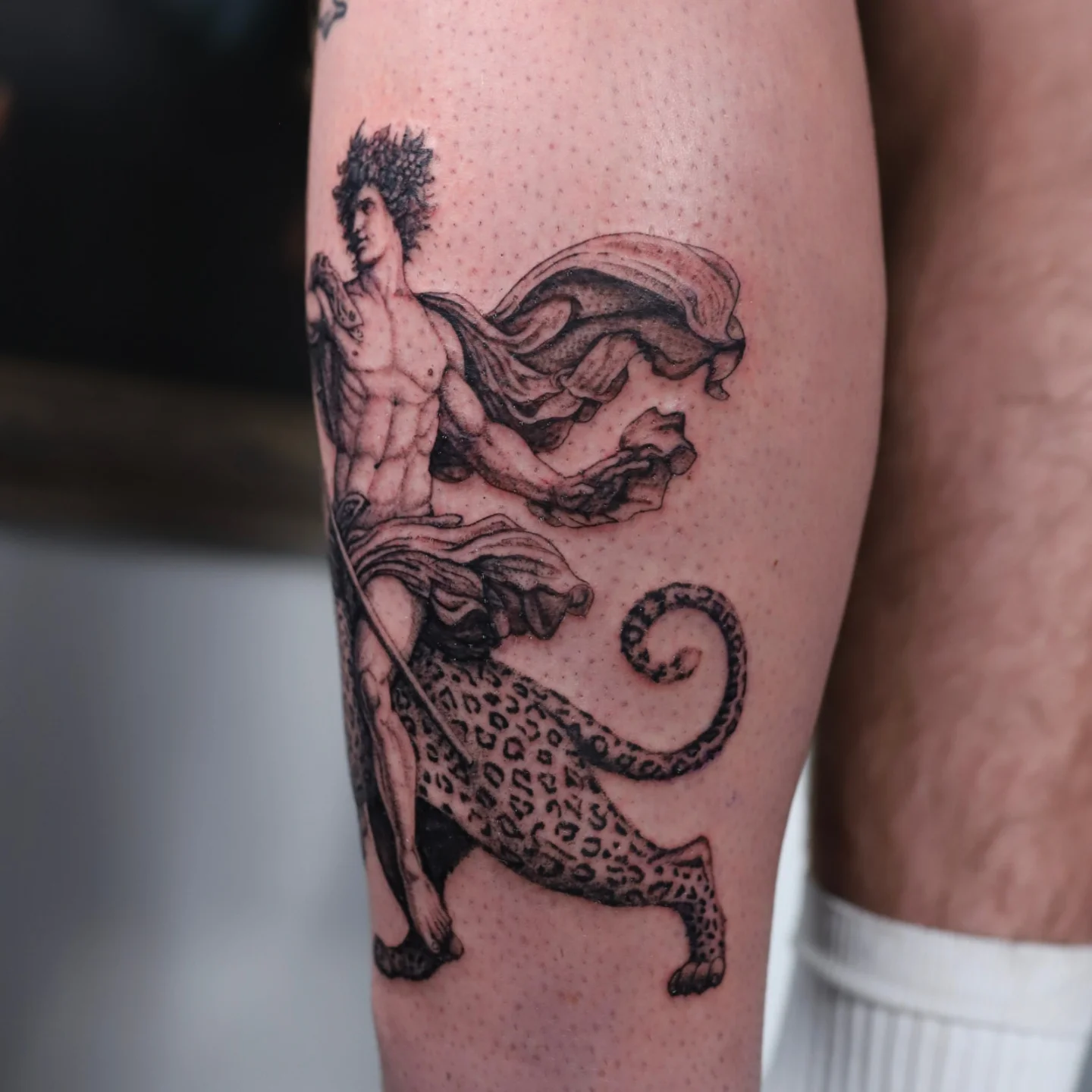 Mythical figure and leopard dotwork tattoo on the thigh by Jessica Sheahan