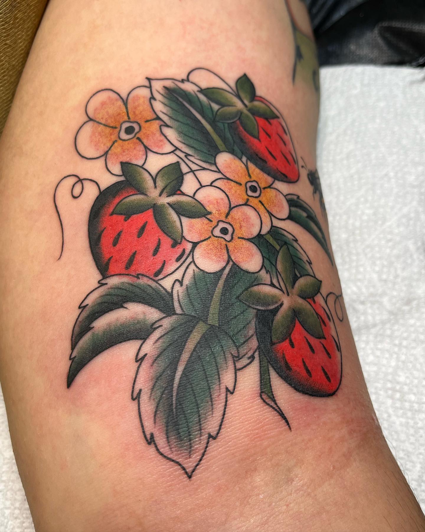 Strawberries and flowers American traditional tattoo on the thigh by Kayla Faircloth, Charlotte, North Carolina