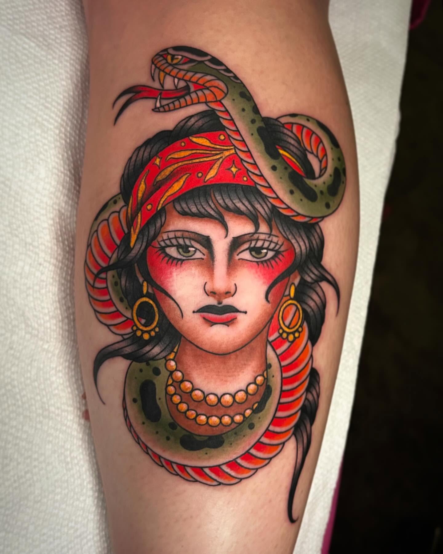 Woman with snake American traditional tattoo on the forearm by Kayla Shoffner