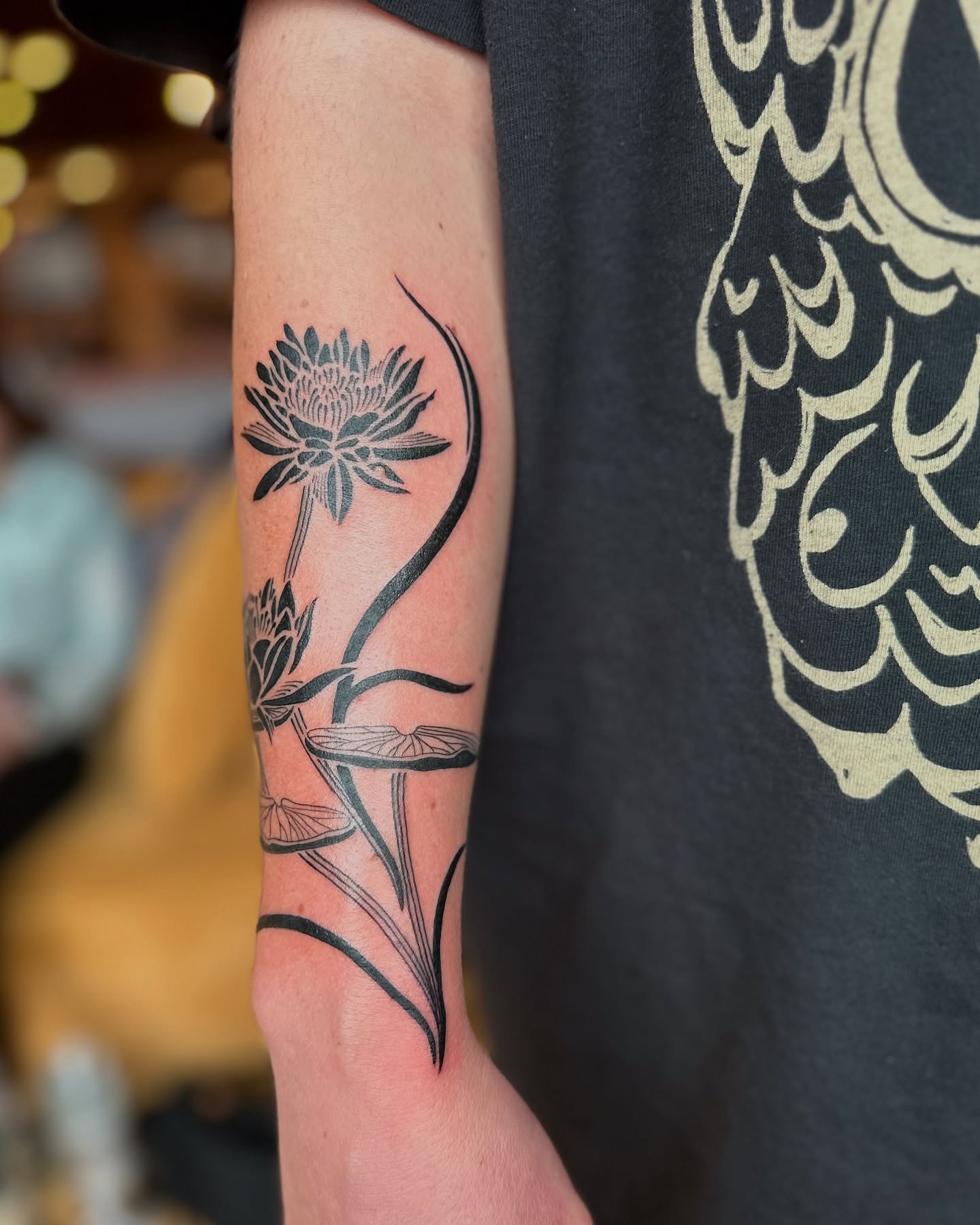 Lotus flower black and grey tattoo on the forearm by Alexandra Gray