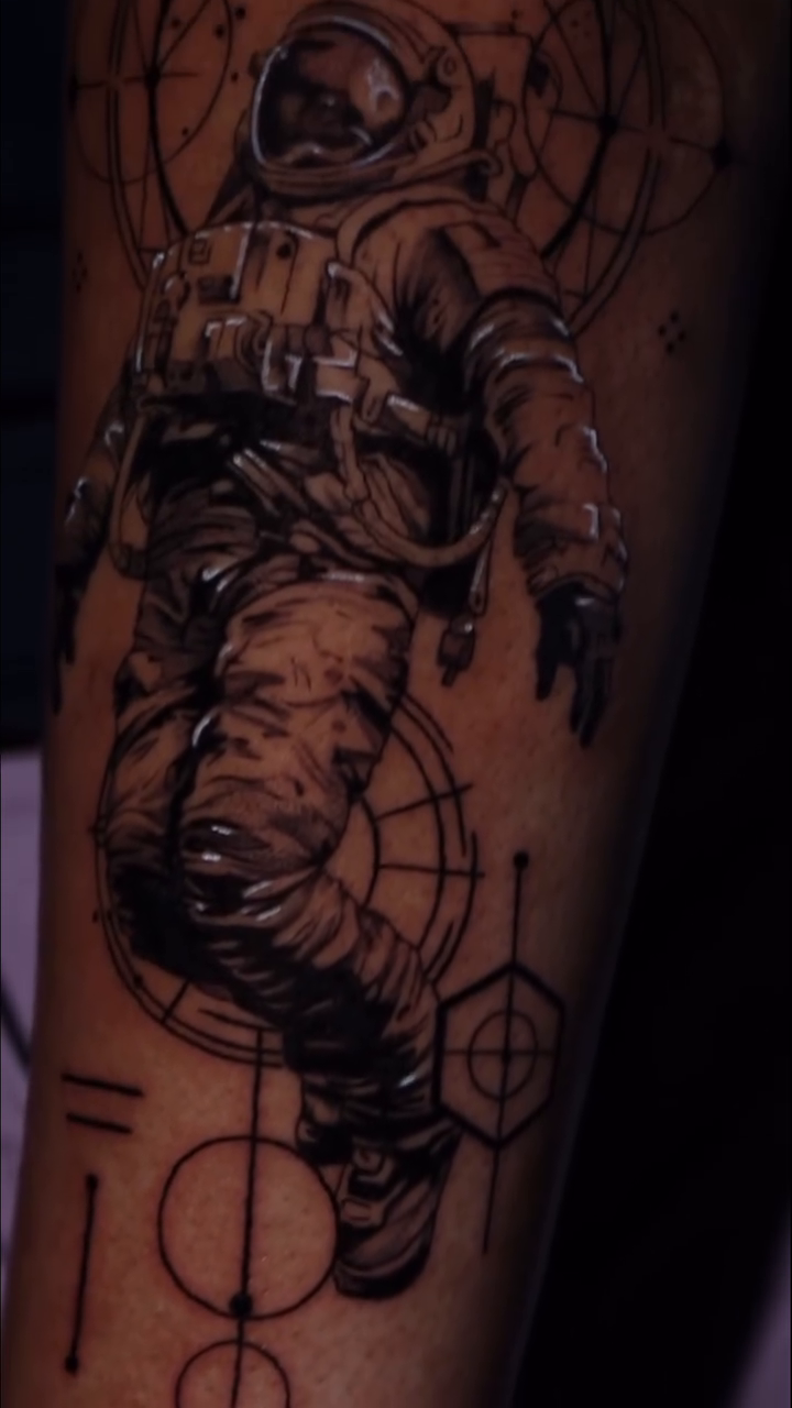 Astronaut floating with geometric patterns realism tattoo by Sophia Cinotti, Washington, District of Columbia