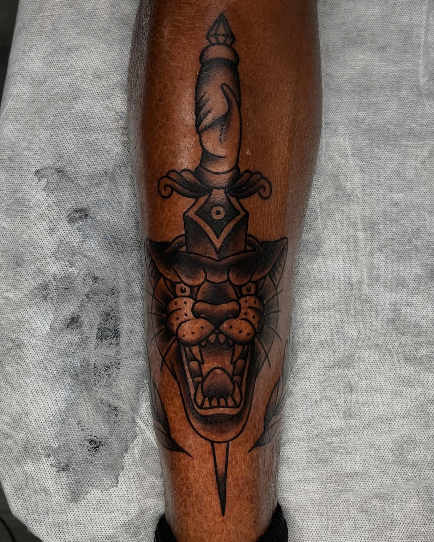 Panther and dagger geometric tattoo on the forearm by Connor Arvay