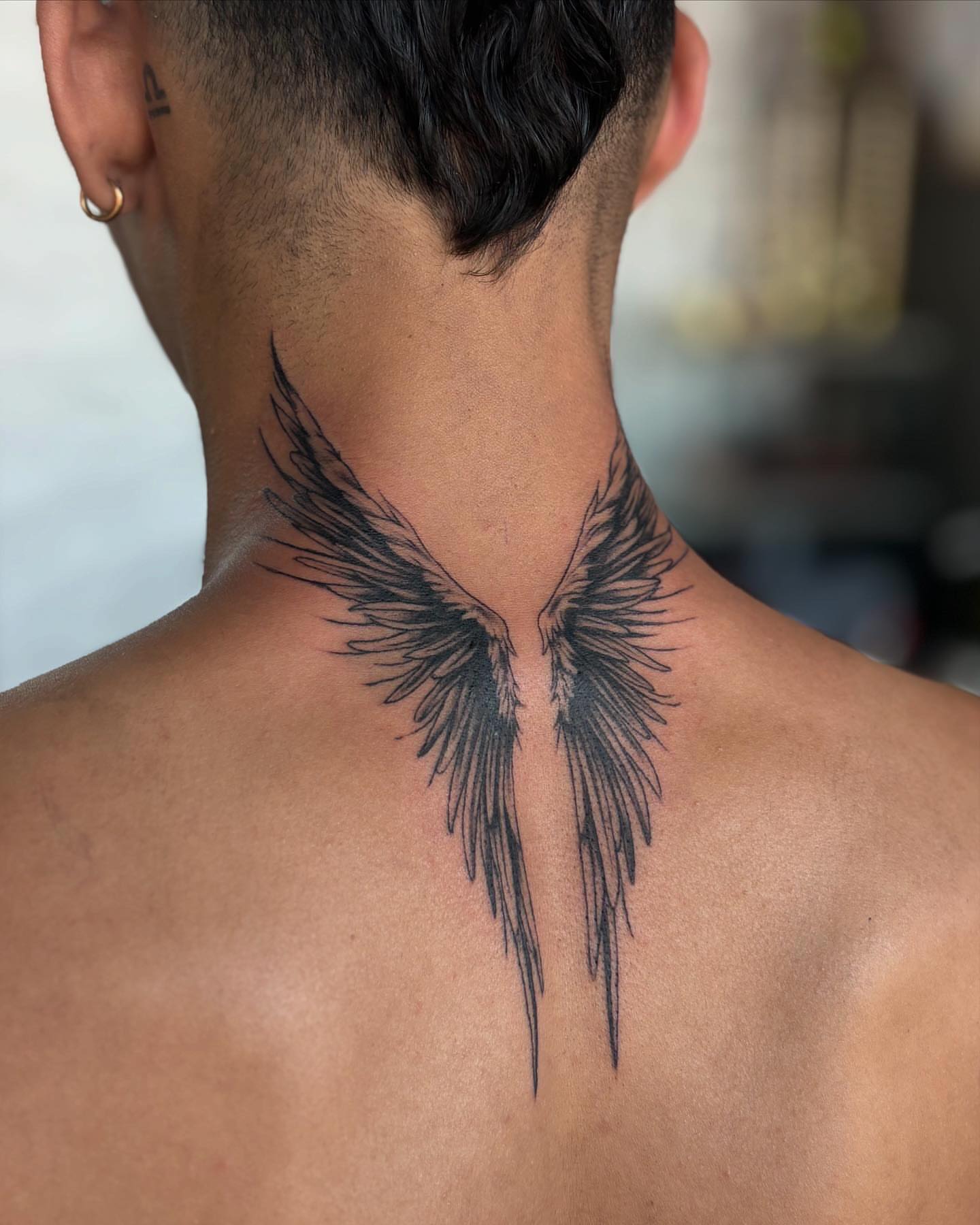 Wings black and grey tattoo on the neck by Tattoos by Tessa