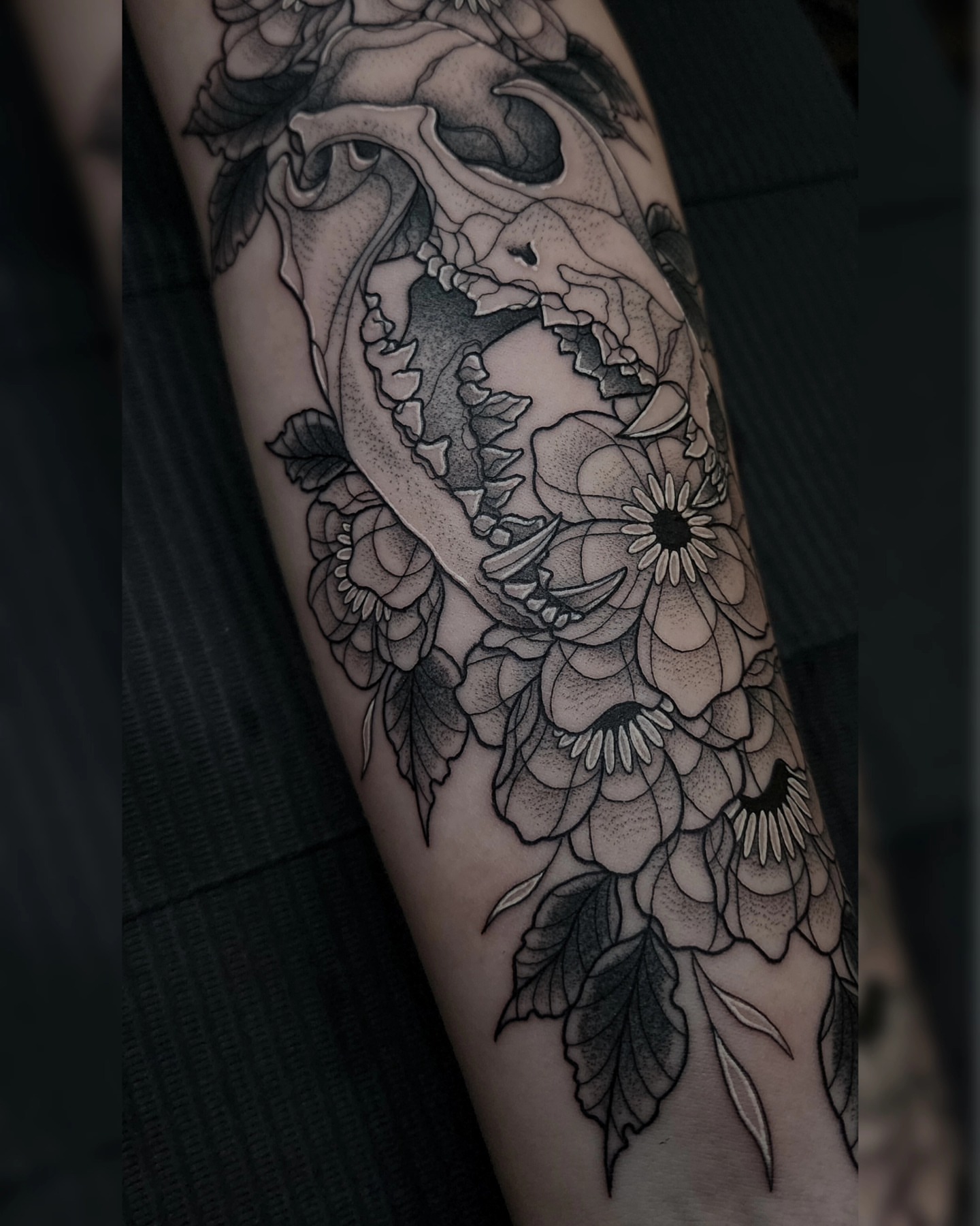 Skull and flowers dotwork tattoo on the forearm by Mariah Giovanna Hodgens