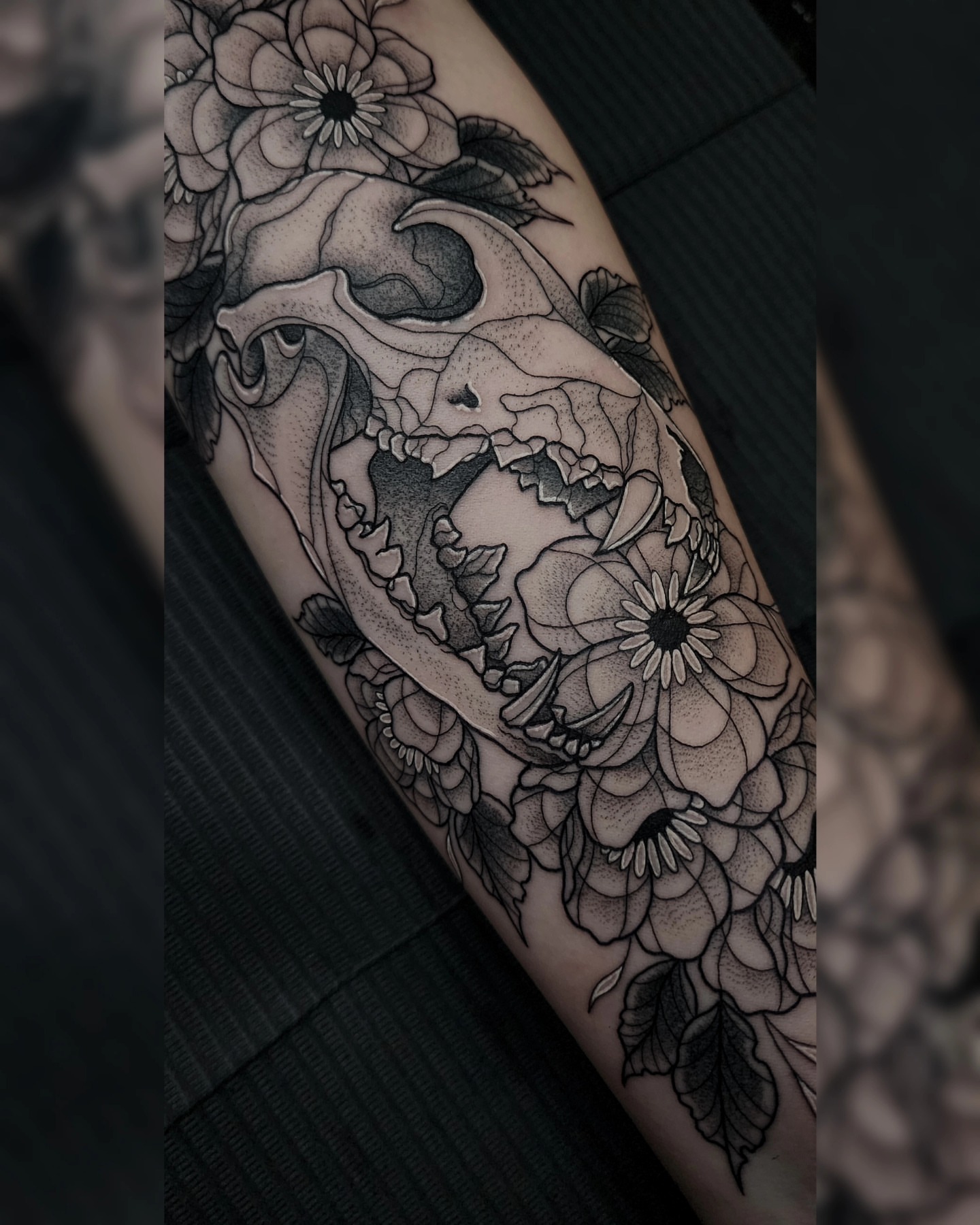 Skull and flowers dotwork tattoo on the forearm by Mariah Giovanna Hodgens