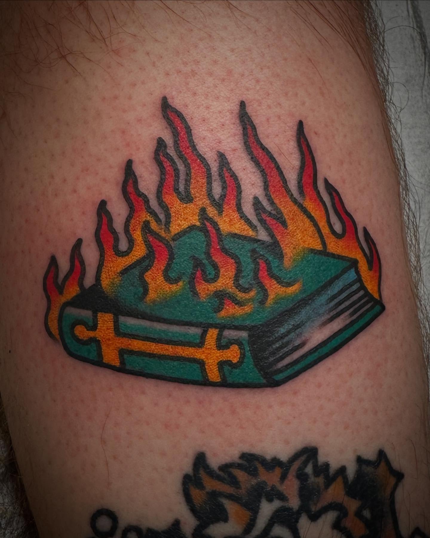 Burning book American traditional tattoo on the thigh by Nathan Rohrbacher, Nashville, Tennessee