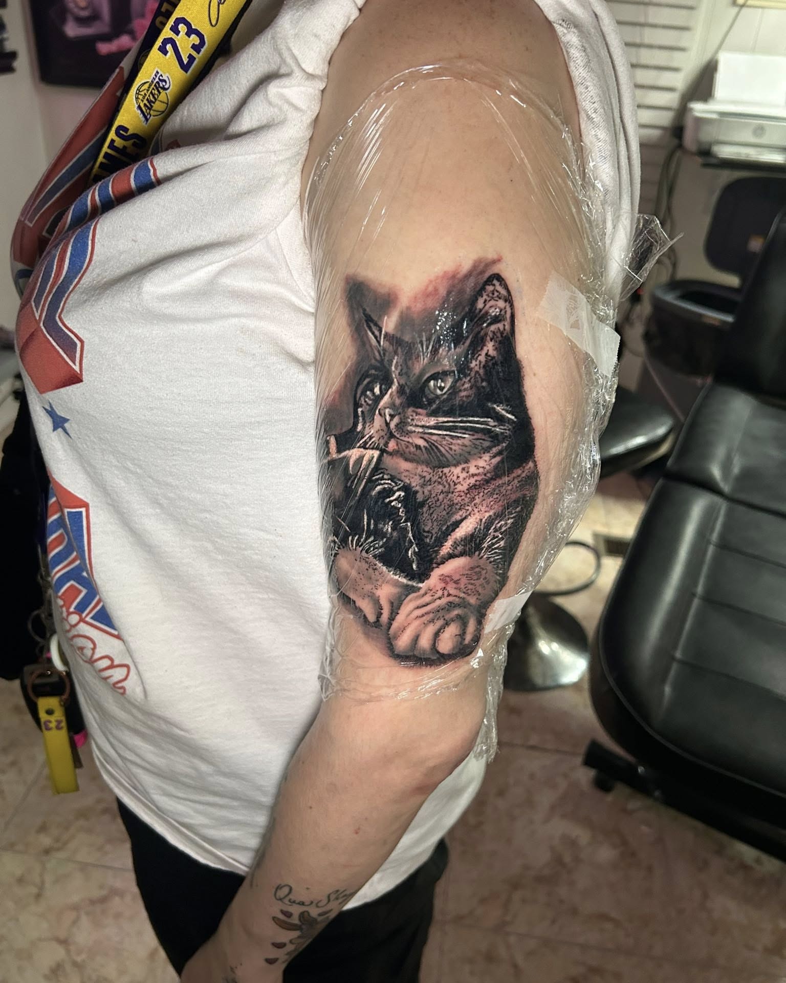 Cat realism tattoo on the upper arm by Bryant Ramirez