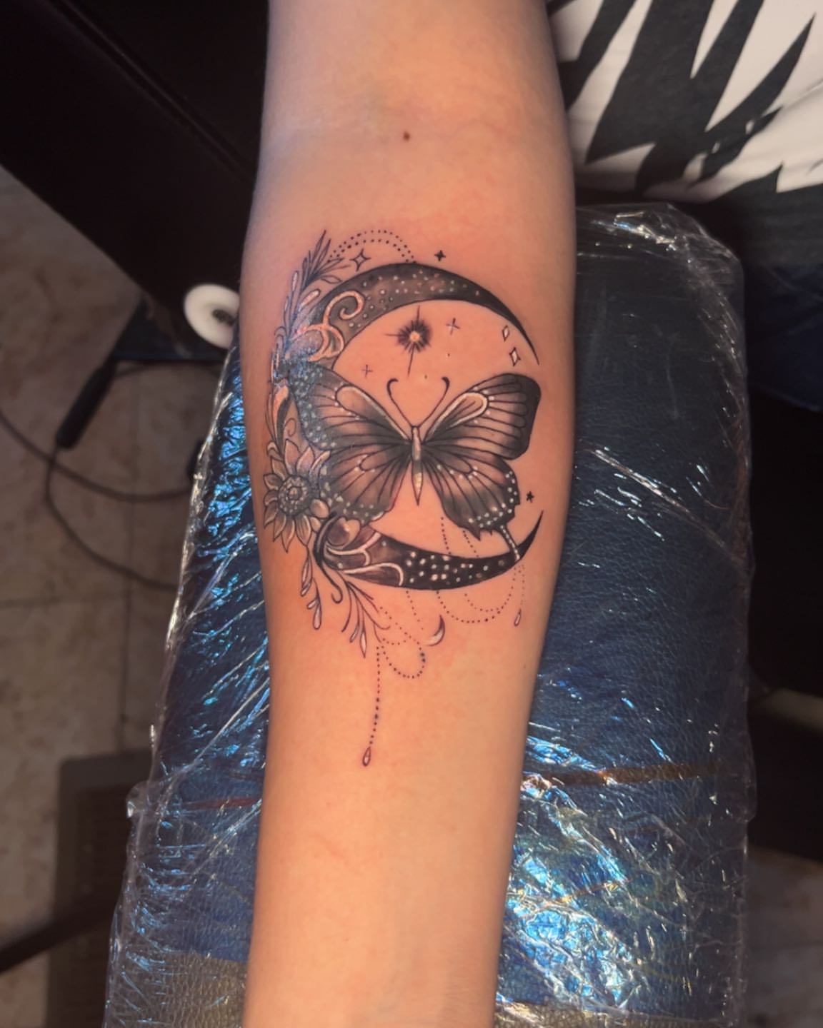 Butterfly and crescent moon dotwork tattoo on the forearm by Bryant Ramirez