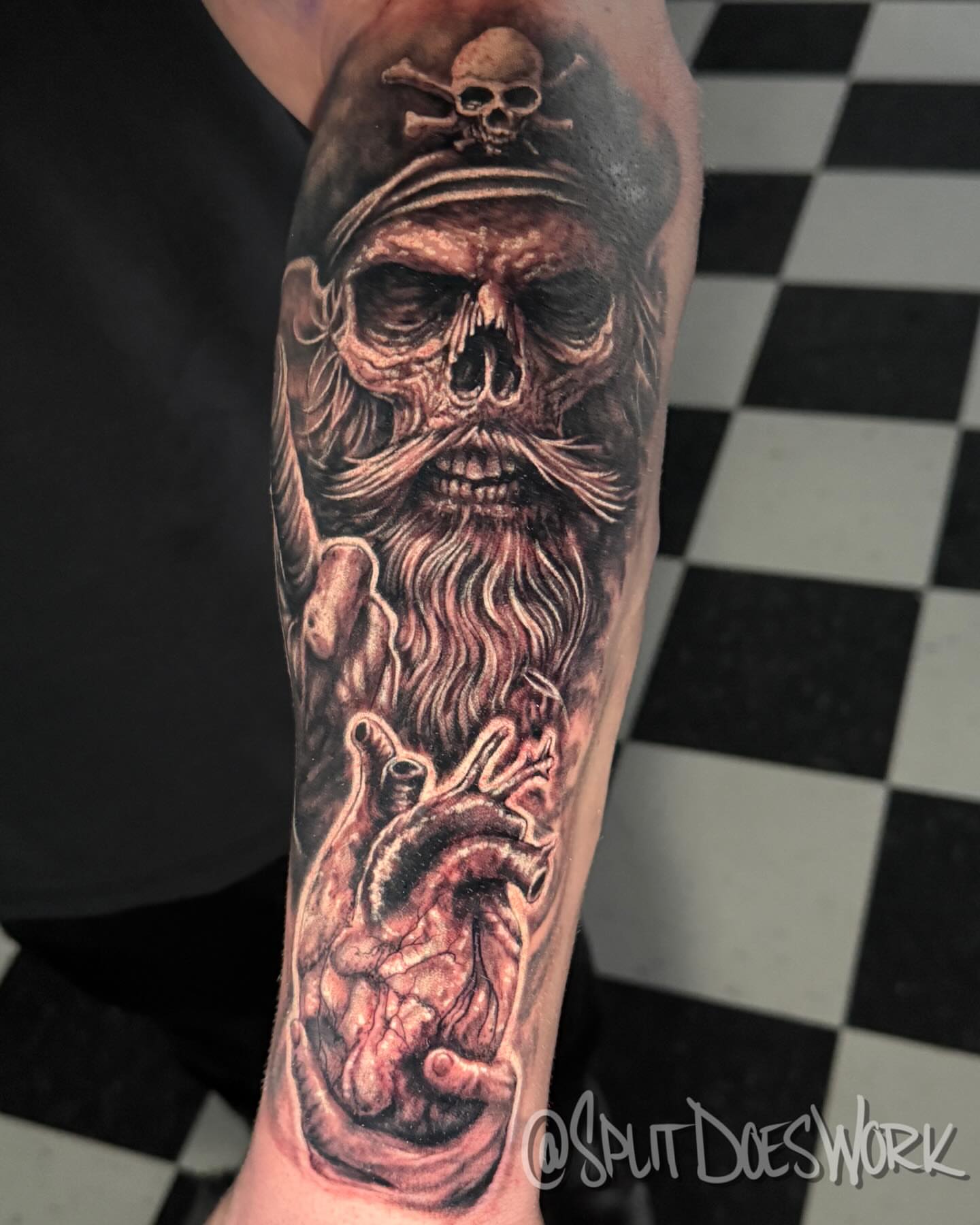 Pirate skull with heart realism tattoo on the forearm by Geoff “Split” DiVittorio