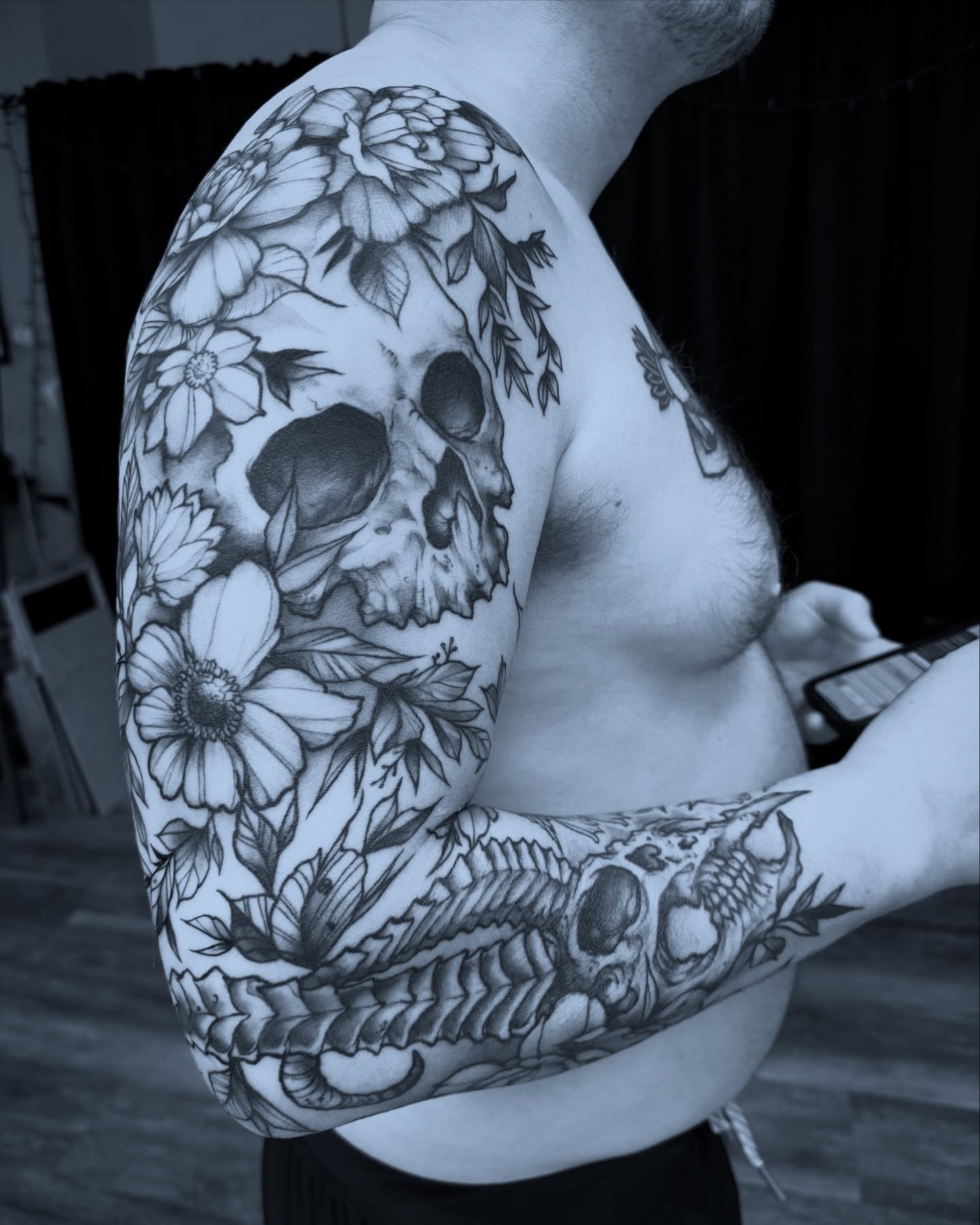 Skull and floral realism tattoo on the upper arm by Michael Langdale