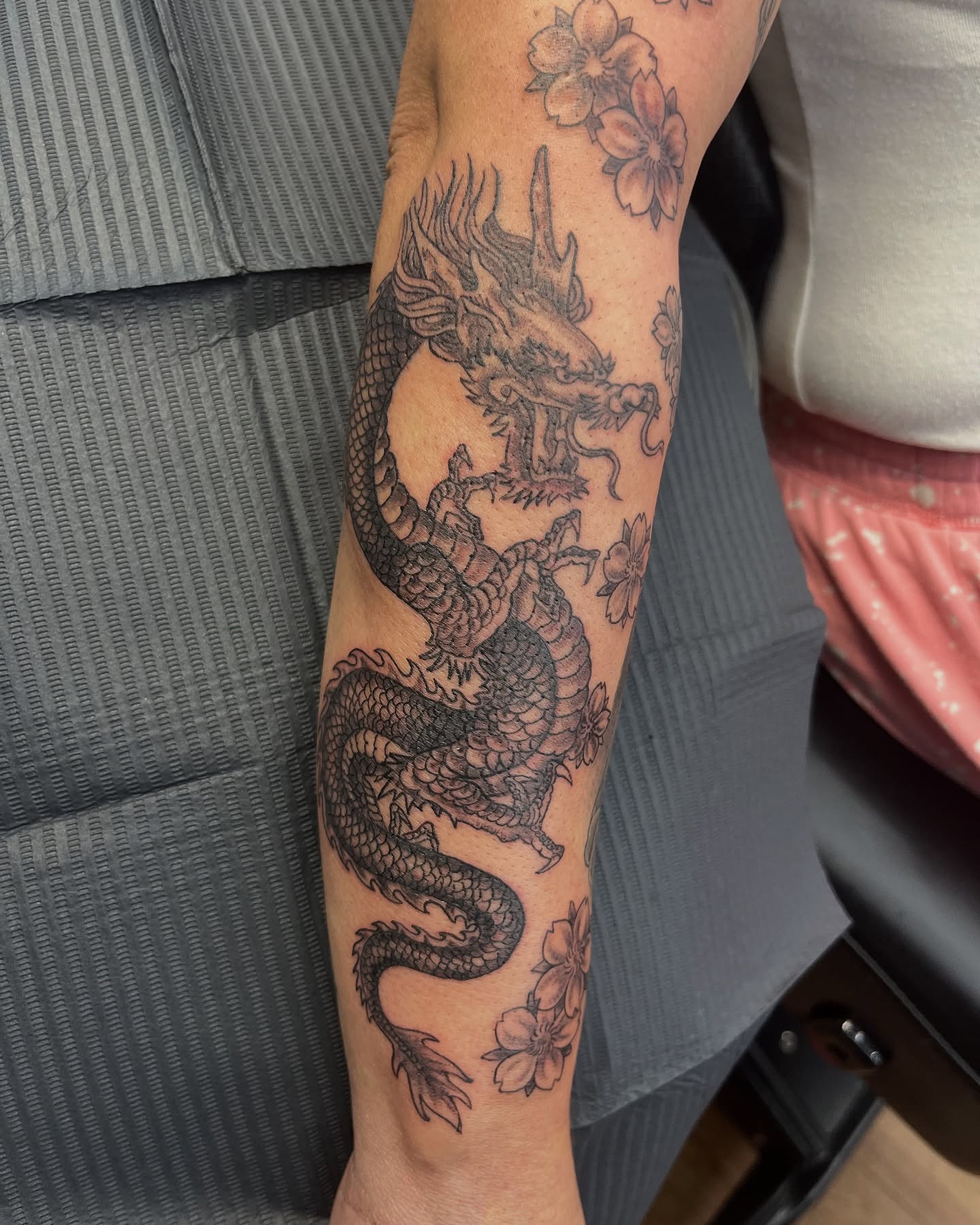 Dragon and cherry blossoms black and grey tattoo on the forearm by ใใใ๐บ๐ฒ